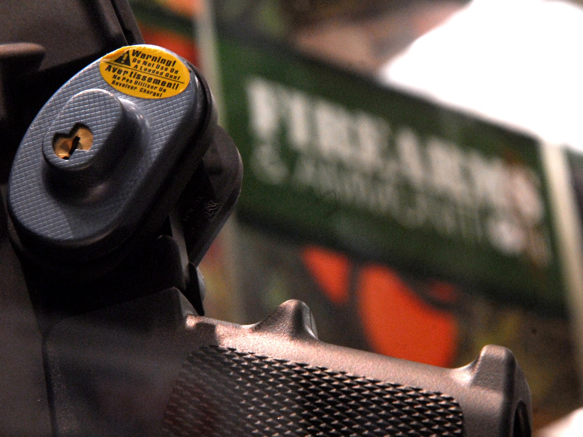 The label on a trigger lock at the firearms and ammunition counter at the Little Rock AFB base exchage states that it should not be used with a loaded weapon.Trigger locks are included with the sale of firearms at the BX. (U.S. Air Force photo by Staff Sgt. Juan Torres)