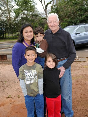 Yvette Nunez and her children (clockwise) Noah, Teegan and Lola pause for a photo with President Jimmy Carter during the Airman and Family Readiness Center train trip to Plains. U.S. Air Force photo by  Tech. Sgt. Vann Miller 