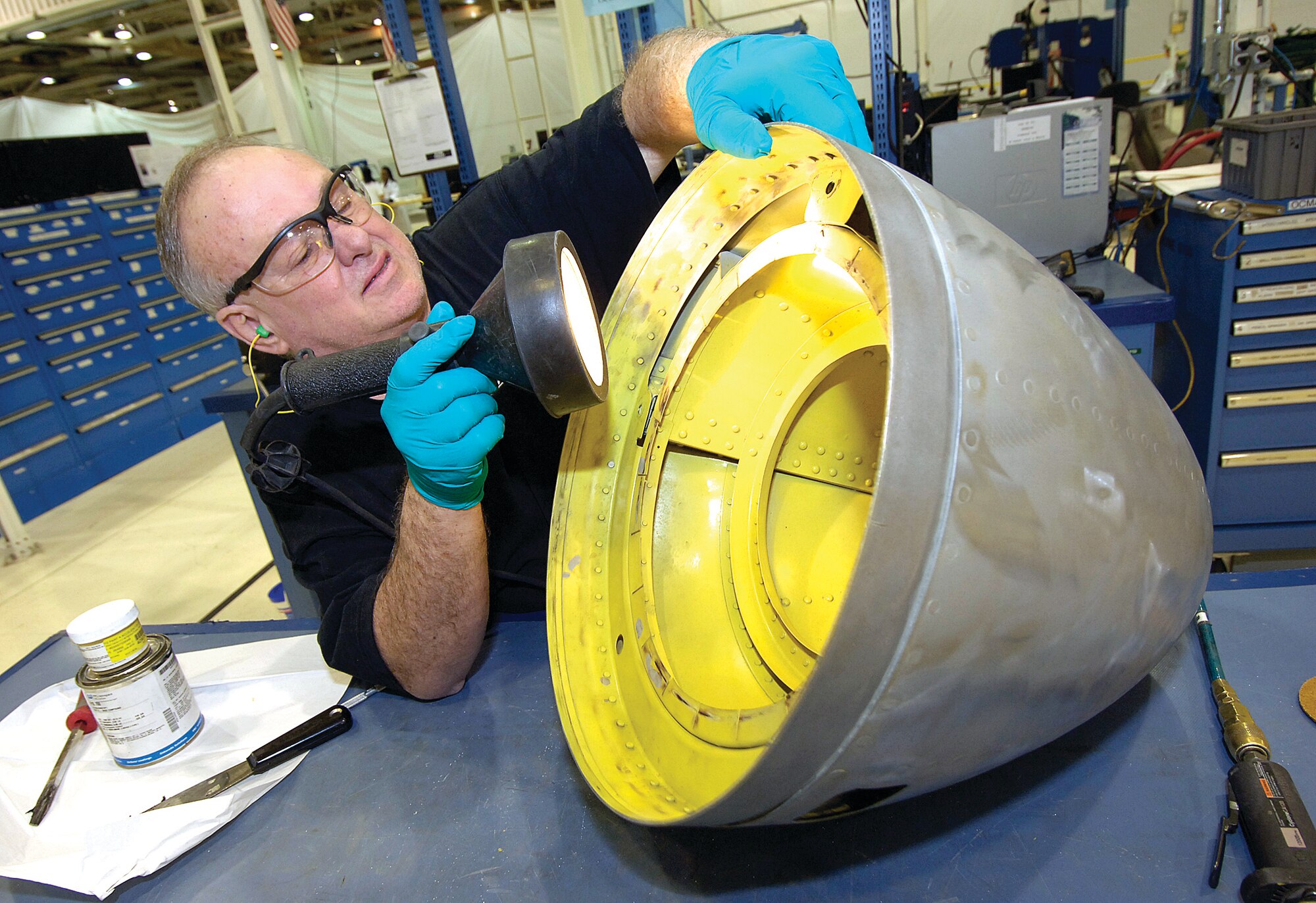 Sheet metal mechanic Pat Hepner, 545th Propulsion Maintenance Squadron, inspects a B-52 engine nose cone in the TF33 Quick Engine Change shop. (Air Force photo by Margo Wright)