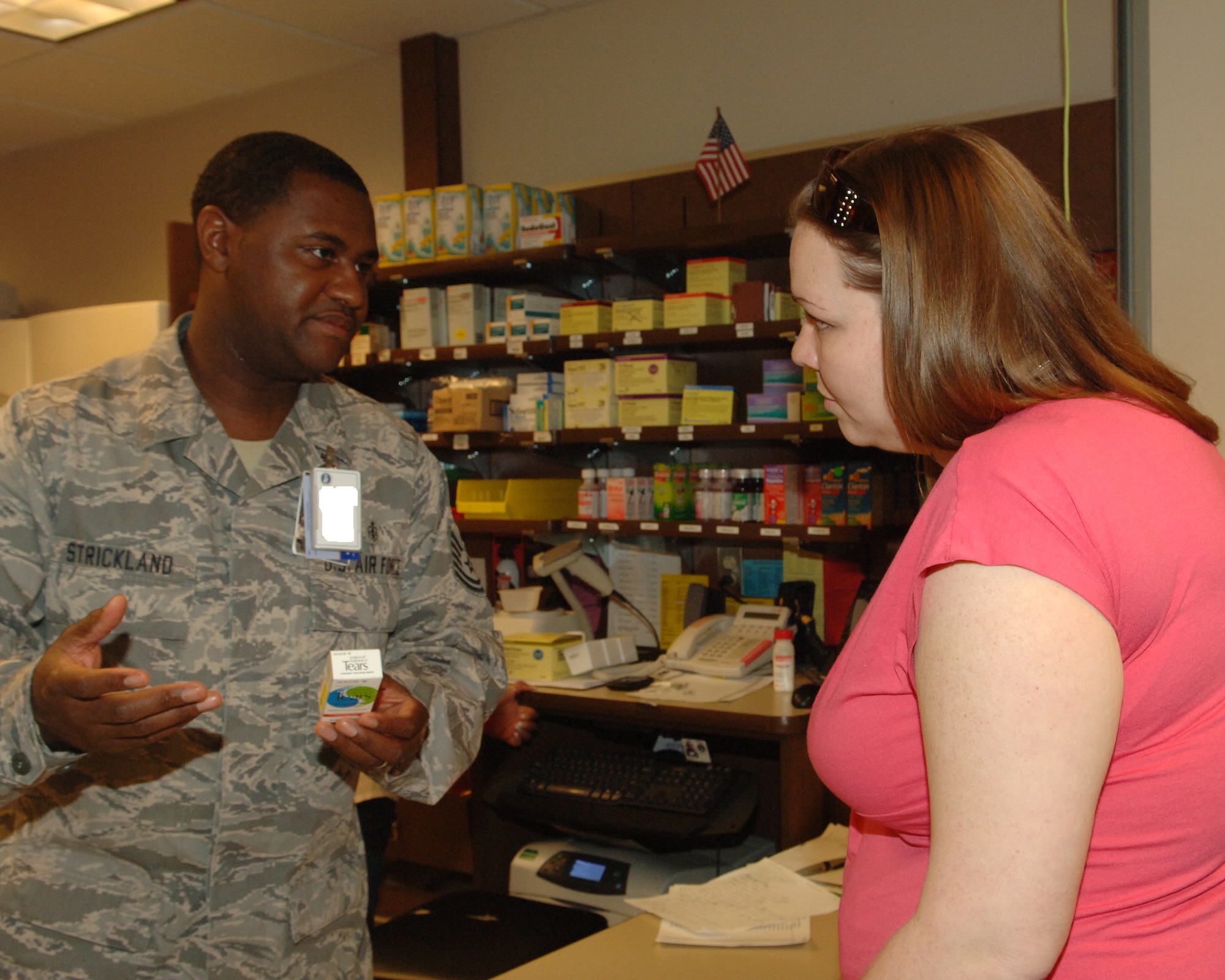 BUCKLEY AIR FORCE BASE, Colo. -- Tech. Sgt. Major Strickland explains a prescription to Amanda Gebhart March 17 at the Buckley Air Force Base pharmacy. (U.S. Air Force photo by Tech. Sgt. Shirley Henderson)