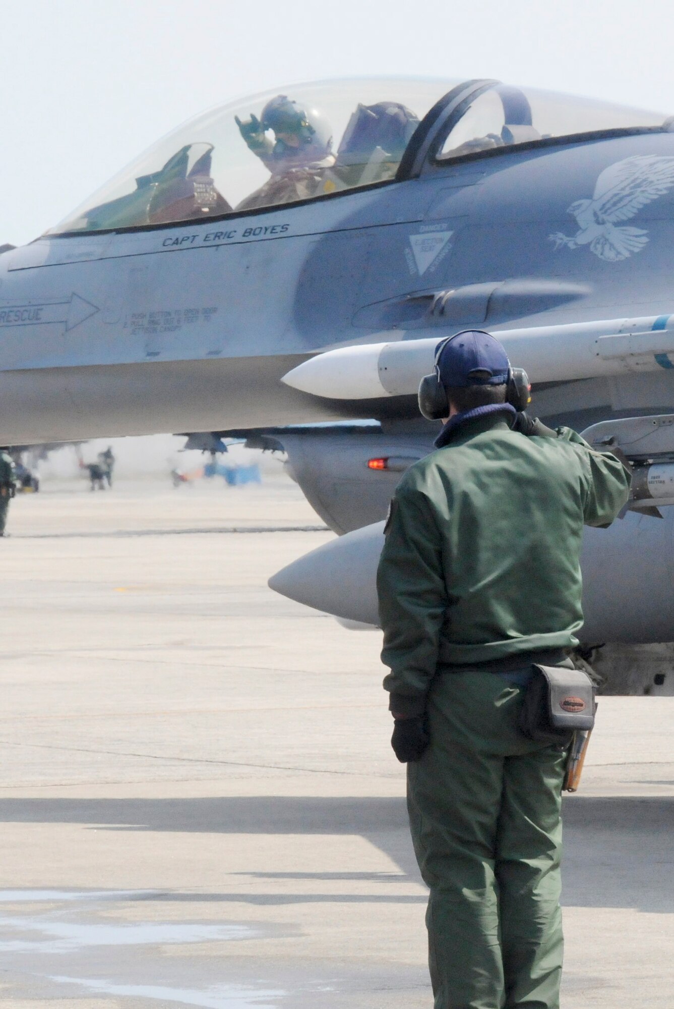 Japan Air Self-Defense Force Staff Sgt. Yuuta Isoya, an F-15 crewchief, salutes Capt. Matt Kenkel, 14th Fighter Squadron pilot, as he taxis out during an aviation training relocation exercise March 11, 2010, at Tsuiki Air Base, Japan. (U.S. Air Force photo/Staff Sgt. Rachel Martinez)
