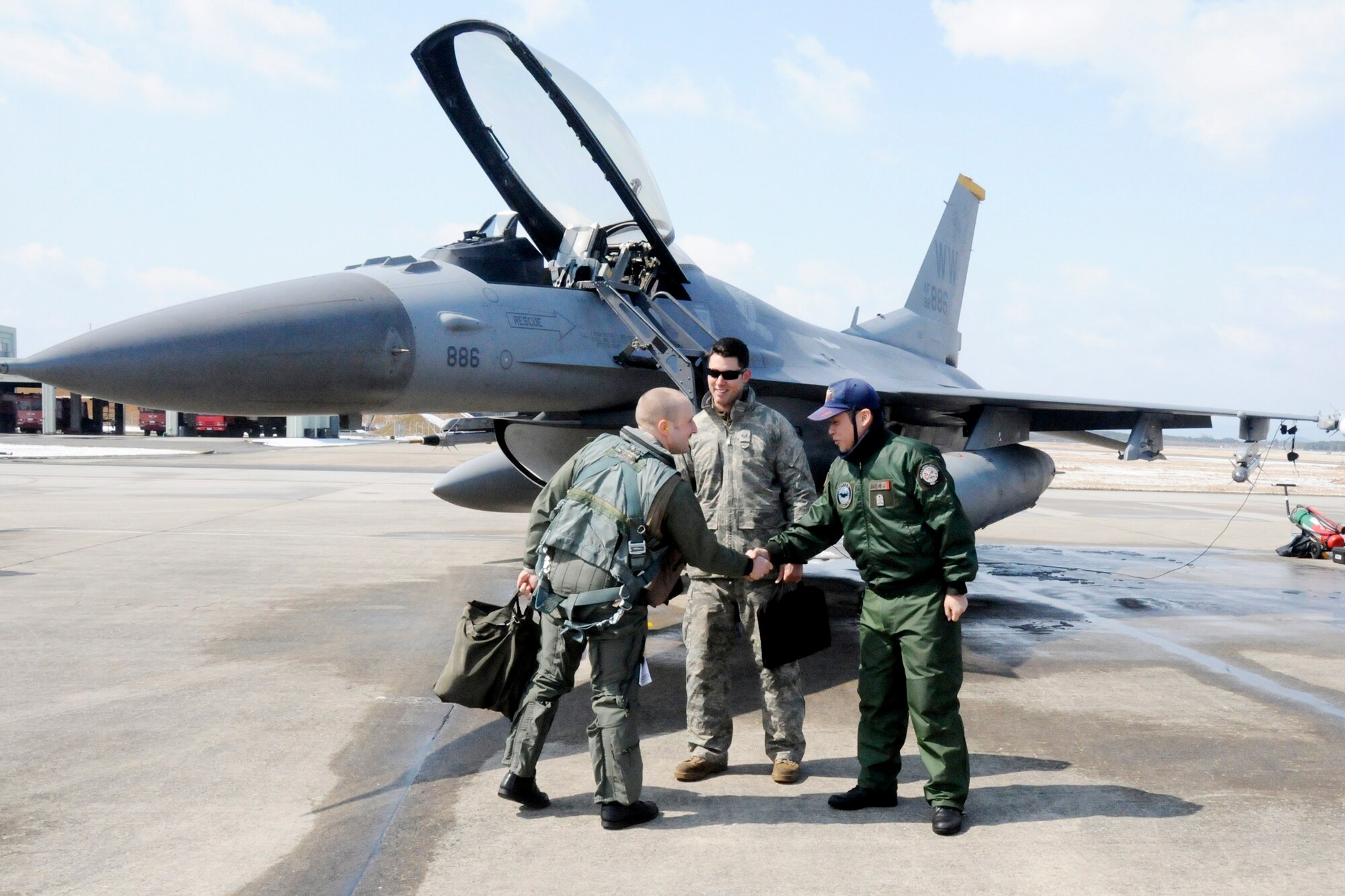 Capt. Matt Kenkel greets his two crewchiefs, Staff Sgt. Christopher Audet and Japan Air Self-Defense Force Staff Sgt. Yuuta Isoya, prior to taking off for a training mission against JASDF F-15 aircraft during an aviation training relocation exercise March 11, 2010, at Tsuiki Air Base, Japan. Captain Kenkel is a 14th Fighter Squadron pilot. (U.S. Air Force photo/Staff Sgt. Rachel Martinez)