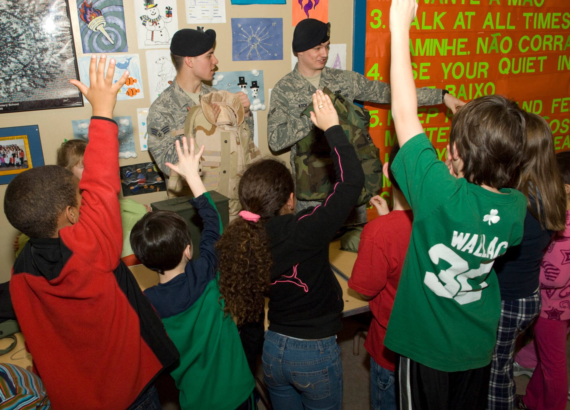During a presentation at the Potter Road Elementary School, Framingham, Mass., Senior Airman Joseph Teresi (Left) and Airman 1st Class Derrick Koch (Right), 66th Security Forces Squadron, show the students some of the protective gear used by today’s security forces personnel.  Five members of the  66th Security Forces Squadron visited the school on March 16 as part of the school’s “Kids With A Cause” program.  (U.S. Air Force photo by Mark Herlihy)