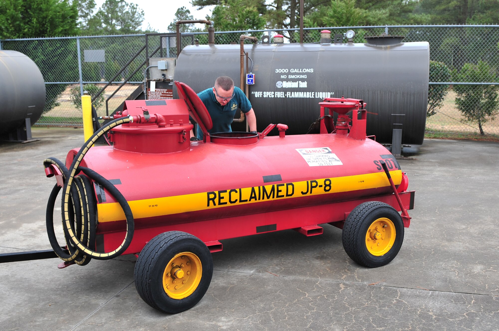 John White, Central Accumulation Site environmental technician, checks a bowser with reclaimed JP-8 jet fuel as it pumps into a larger holding tank on Seymour Johnson Air Force Base, N.C., March 12, 2010. Reclaimed fuel is not suitable for use in the F-15E Strike Eagle; however, the base recycles it for other uses like fuel oil to heat houses after being blended with other fuel sources. White hails from LaGrange, N.C. (U.S. Air Force photo/Senior Airman Rae Perry)