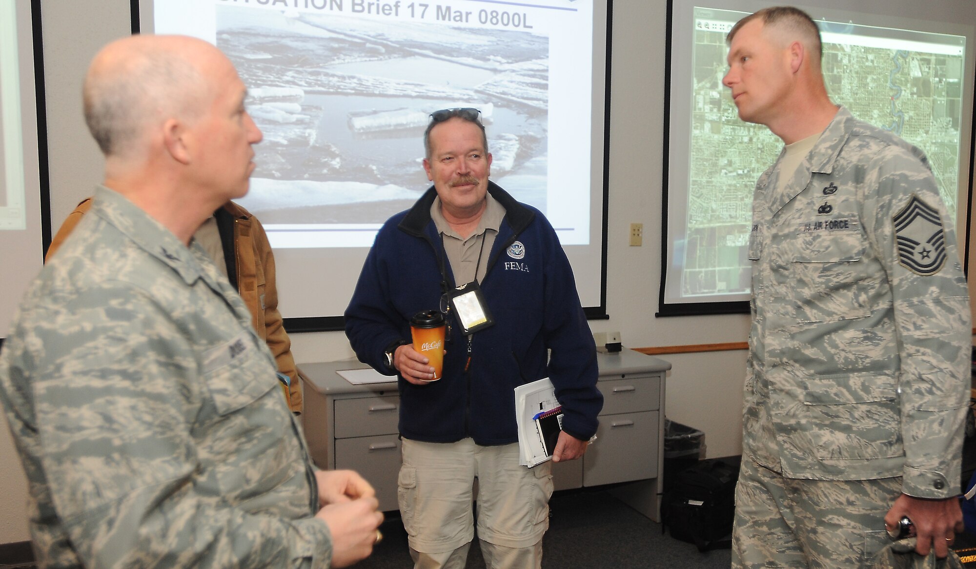 Col. Joseph Douez (left), 319th Mission Support Group commander and the Emergency Operations Center Director, Jeffrey Bezore (center), Federal Emergency Management Agency Staging Area Direct Supervisor, and Chief Master Sgt. David Carlson, 319th MSG Superintendent, discuss flood relief plans March 17 during an EOC meeting on Grand Forks Air Force Base, N.D. The base recently received a FEMA mission allowing it to become an incident support base and a staging ground for emergency operations for flood relief efforts in the local area.  (U.S. Air Force photo by Staff Sgt. Suellyn F. Nuckolls) 