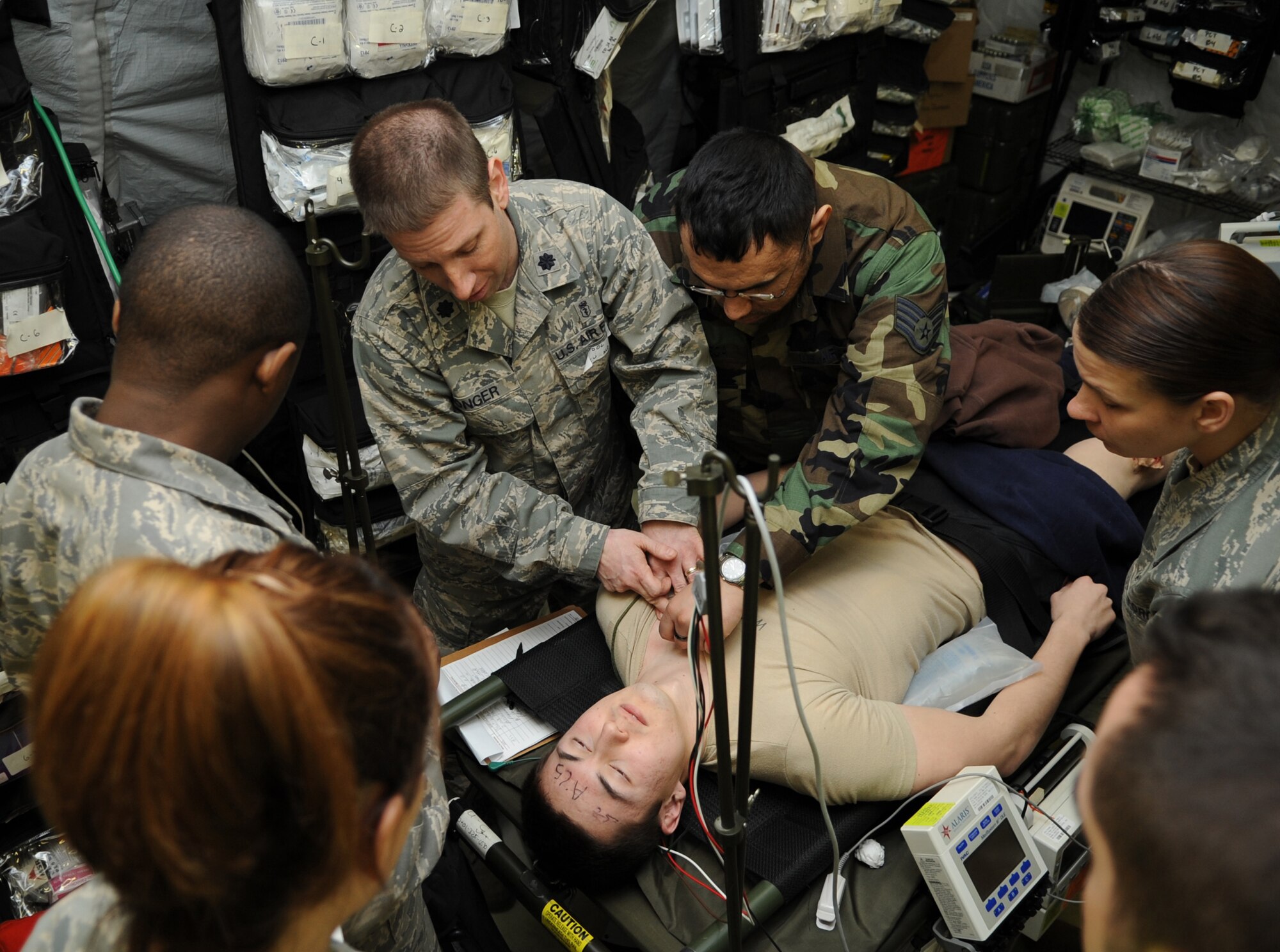 U.S. Air Force Lt. Col. Nicholas Conger, 86th Medical Squadron medical services flight commander, helps stabilize a simulated wound on a role player during  a mass casualty exercise during the Expeditionary Medical Support (EMEDS) Mobile Course training, Ramstein Air Base, Germany, March 17, 2010. The EMEDS course teaches and evaluates corps specific field situations as well as offers updates in Air Force Medical Service concept of operations and doctrine. It also teaches setup and packing out of a field EMEDS compound, deployed operations, field medical, nursing and operational support equipment proficiency, field exercises to both emphasize and evaluate learning of concepts taught. (U.S. Air Force photo by Airman 1st Class Caleb Pierce)