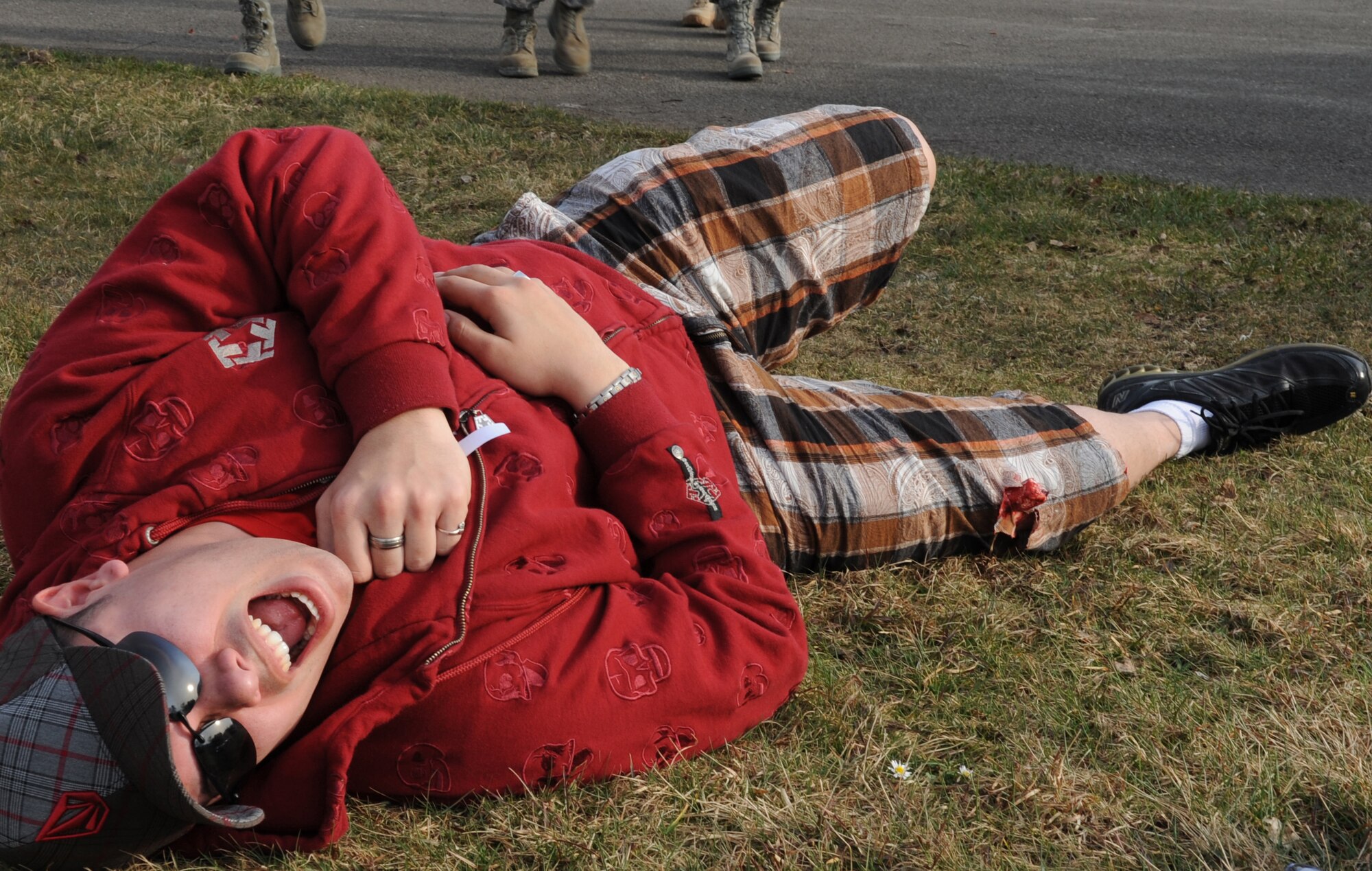 U.S. Air Force member from the 86th Communications Squadron simulates an injury during a mass casualty exercise in support of the Expeditionary Medical Support (EMEDS) training Ramstein Air Base, Germany, March 17, 2010. The EMEDS course teaches and evaluates corps specific field situations as well as offers updates in Air Force Medical Service concept of operations and doctrine. It also teaches setup and packing out of a field EMEDS compound, deployed operations, field medical, nursing and operational support equipment proficiency, field exercises to both emphasize and evaluate learning of concepts taught. (U.S. Air Force photo by Airman 1st Class Caleb Pierce)