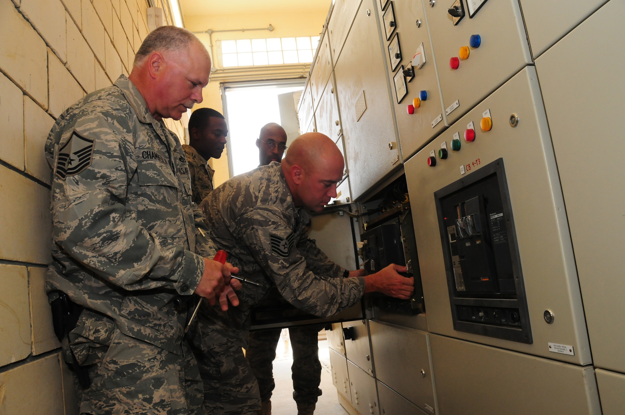 Under U.S. Air Force Master Sgt. Mark Chamberlin's supervision, left, 386th Expeditionary Civil Engineer Squadron electricians Tech. Sgt. Jimmy McAnally, Staff Sgt. Joshua Freeman, and Airman 1st Class Alvin Walker, service circuit breakers and repair a previously condemned transformer March 12, 2010 at an air base in Southwest Asia saving thousands of dollars in replacement and contracting costs. Sergeant Chamberlin is a plumber with the 386th ECES. All four Airmen are deployed from the 137th Air Refueling Wing at Will Rogers Air National Guard Base, Okla. (U.S. Air Force photo by Staff Sgt. Lakisha Croley/Released)