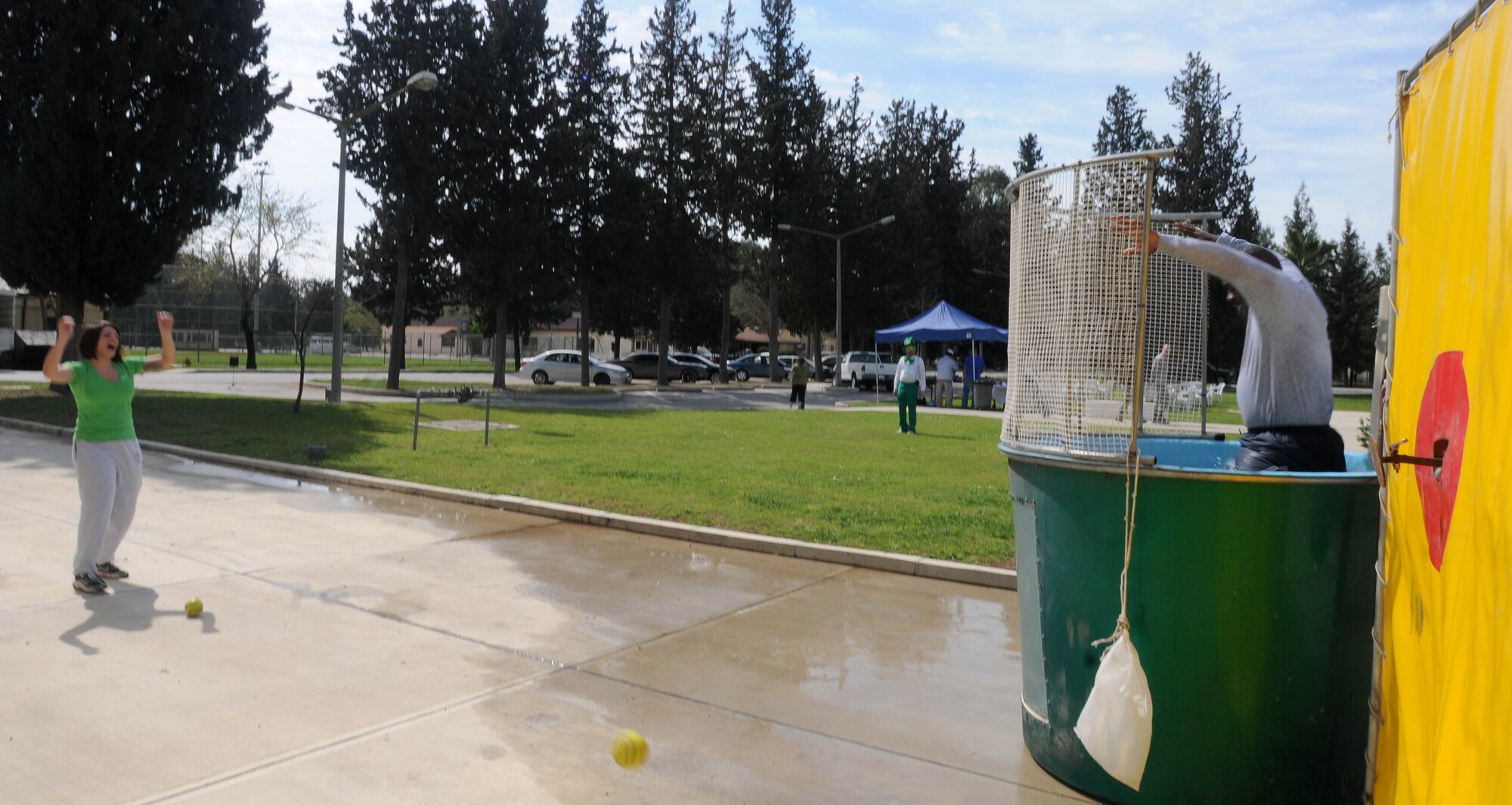 Airman 1st Class Amber Ashcraft, 39th Air Base Wing Public Affairs, celebrates after throwing a softball at the bulls eye of a dunk tank and knocking in Chief Master Sgt. Marcus Snoddy, 39th ABW command chief, Wednesday, March 17, 2010 at Incirlik Air Base, Turkey.  Airman Ashcraft had to pay $2 for three chances to dunk Chief Snoddy.   All proceeds went to the Air Force Assistance Fund, a fundraising campaign that distributes aid money to four charities.  (U.S. Air Force photo/Senior Airman Ashley Wood)
