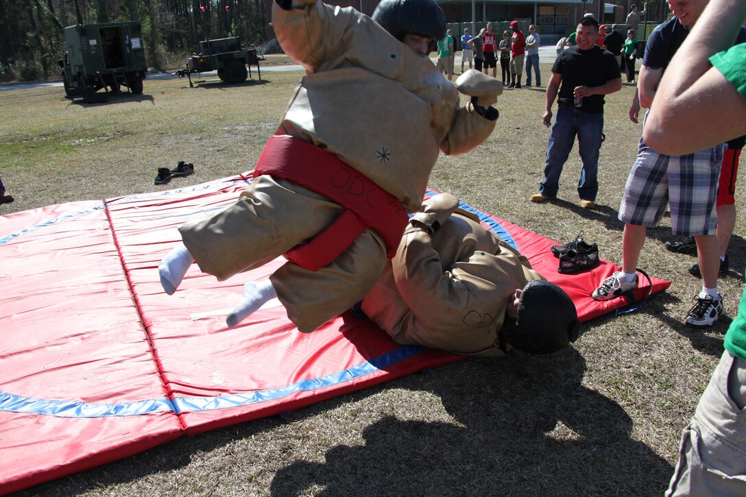 A pair of Marine Air Control Squadron 2 Marines bring some acrobatics sumo wrestling during the family day event held at MACS-2’s parade field, March 19. MACS-2 Marines and their family members enjoyed the day competing in different events, as well as learning about equipment MACS-2 uses.