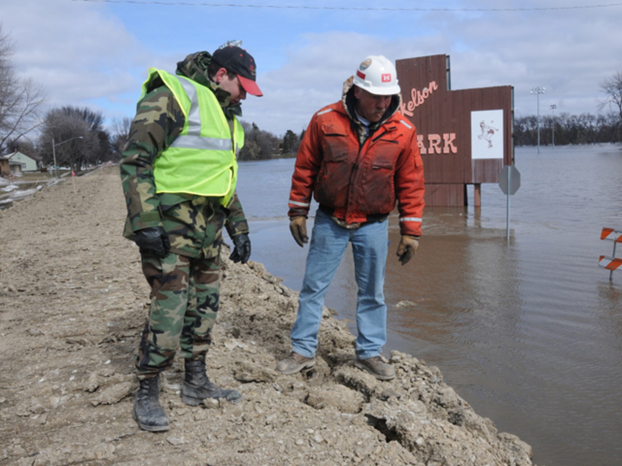 Staff Sgt. Wayne Baumbach, of the 119th Communications Flight, points out a possible problem area in a clay dike to Kevin Ressie, of the U.S. Army Corp of Engineer (St. Paul office), March 19, Fargo, N.D.  Baumbach is a North Dakota Air National Guard flood dike walker, who is tasked with watching the flood dikes for possible problems and also to keep people from climbing up on the dikes. Ressie is responsible for construction and maintenance of the dikes. (DoD photo by Senior Master Sgt. David H. Lipp) (Released)