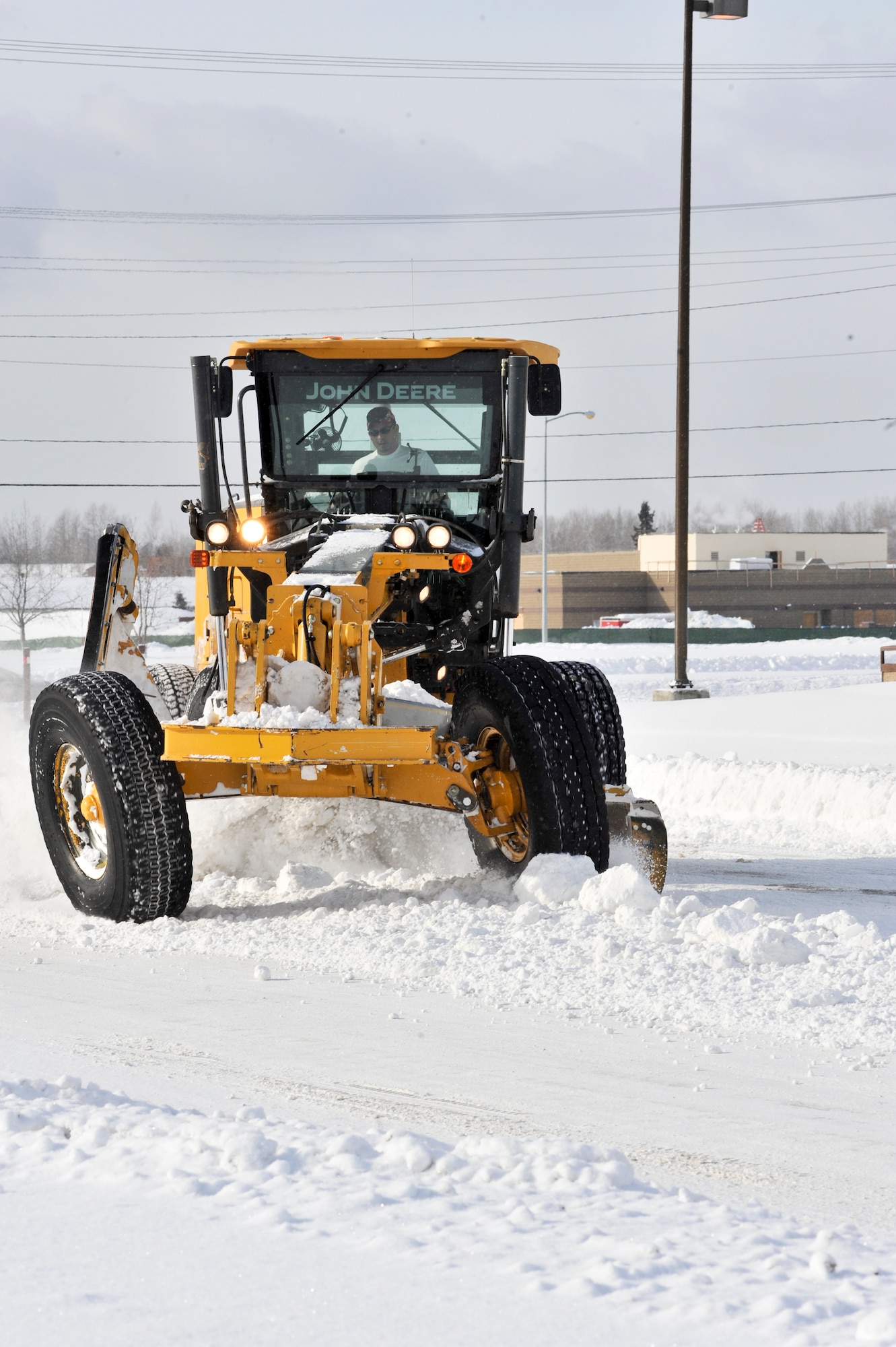 ELMENODRF AIR FORCE BASE, Alaska – Michael Cannon, 3rd Civil Engineer Squadron airfield clearing equipment operator, plows a snow berm. Large portions of the 3rd CES team’s job are preventative measures to keep common problems from occurring in the future. (U.S. Air Force photo/ Airman 1st Class Jack Sanders)