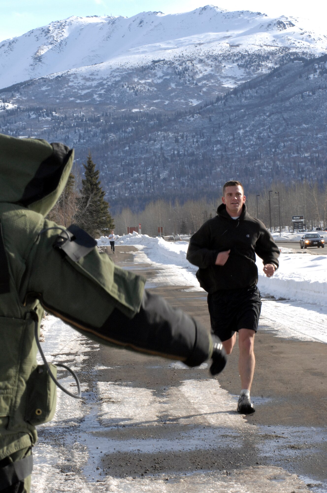 ELMENDORF AIR FORCE BASE, Alaska – A member of the 3rd Civil Engineer Squadron Explosive Ordinance Disposal gives a high five to a runner as he crosses the finish line for the EOD five kilometer Fun Run March 19. (U.S. Air Force photo/ Airman 1st Class Jack Sanders) 