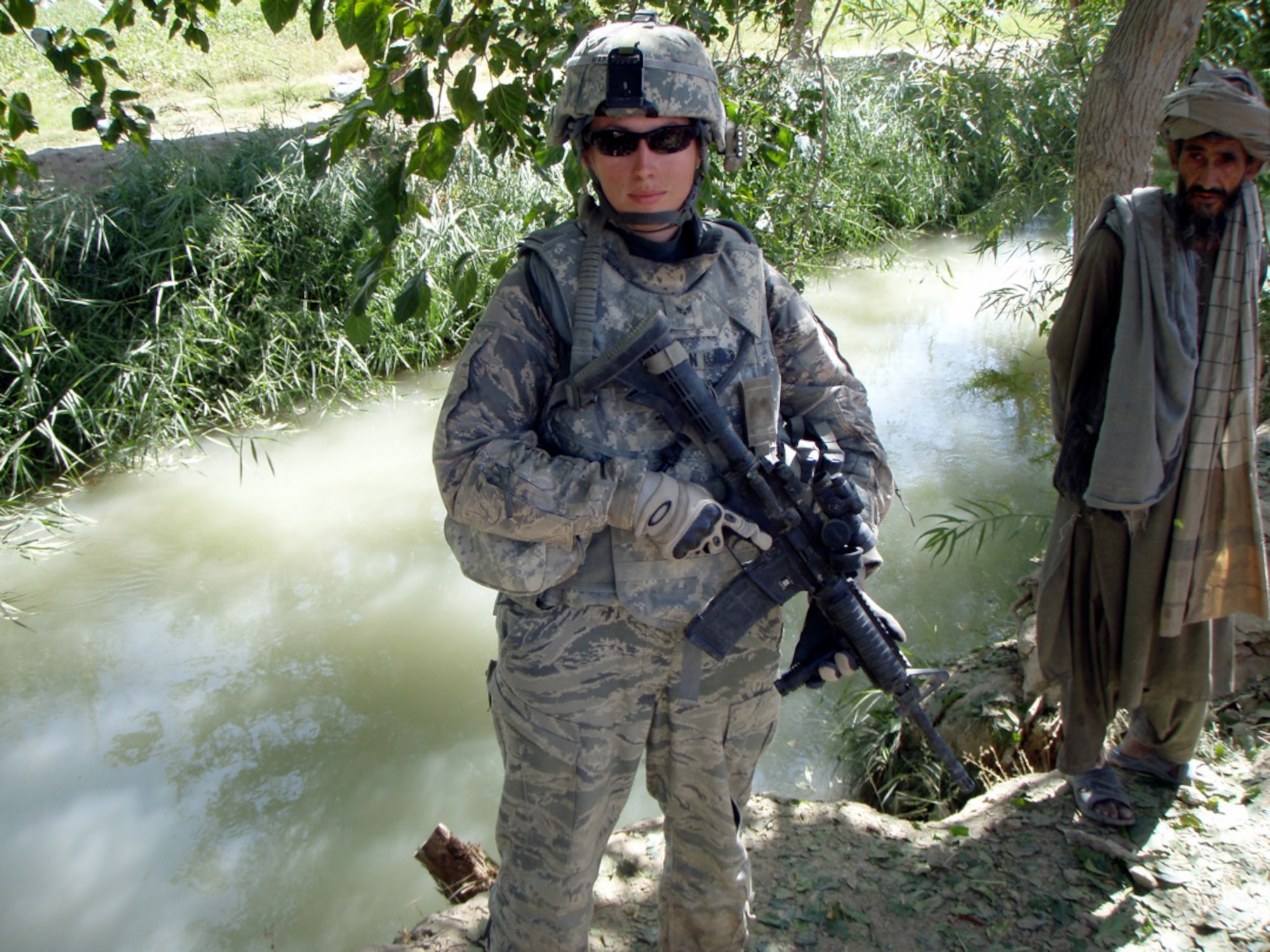 Senior Airman Marie Martinson patrols the area with an Afghan man while during deployment to Afghanistan.  Airman Martinson is an explosive ordnance disposal technician at the 88th Air Base Wing at Wright-Patterson Air Force Base, Ohio. (U.S. Air Force photo)  