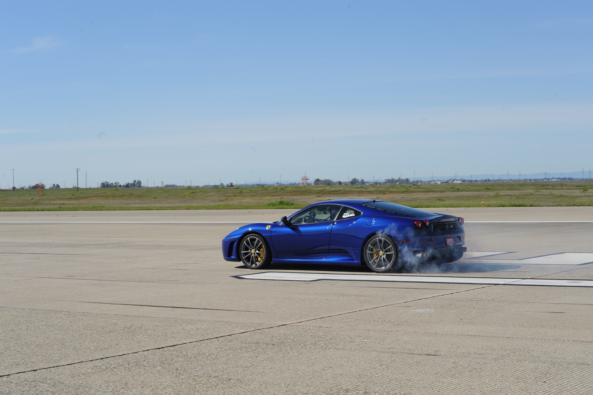 Open-wheel driver Paul Tracy burns rubber as he takes off on a one-mile speed run March 15 on the flightline. Tracy piloted the Ferrari F430 during filming of a SPEED Channel Battle of the Supercars edpisode. (Air Force photo by Senior Airman Christopher Ruano)