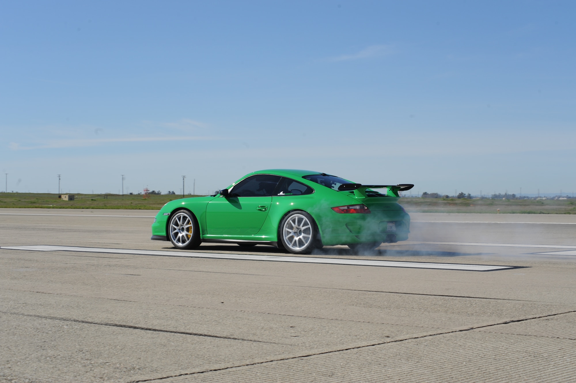 Tanner Faust peels out in a Porsche 997 GT3RS March 15 on the flightline during a filming of SPEED Channel's Battle of the Supercars. During the filming, both the Porsche and Ferrari F430 broke the 200 miles per hour barrier. (Air Force photo by Senior Airman Christopher Ruano)