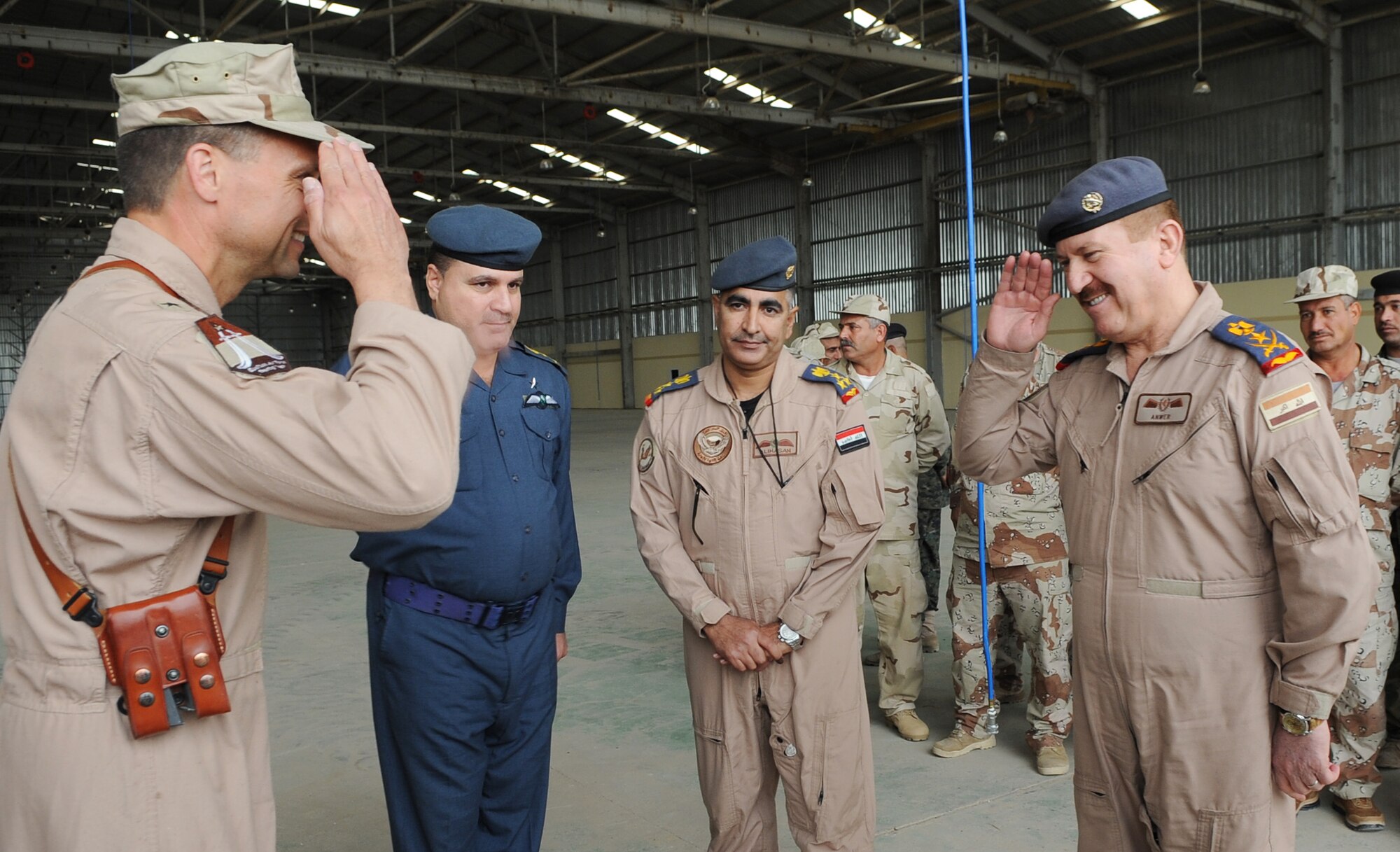 Brig. Gen. Scott Hanson, 321st Air Expeditionary Wing commander, and Staff Lt. Gen. Anwer Ameen, Iraqi air force commander, exchange salutes March 10, 2010, following the transfer of the newly restored Skeleton Hangar on Kirkuk Regional Air Base to the Iraqi air force. Members of the Iraq Training and Advisory Mission-U.S. Air Force and the Iraqi air force participated in the transfer ceremony. (U.S. Air Force photo/Staff Sgt. Tabitha Kuykendall)