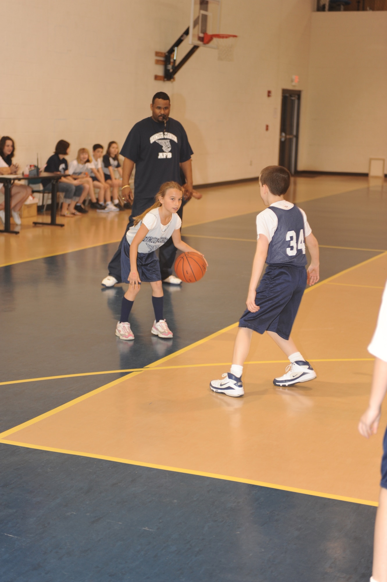 Lauryn Freeman, Sharks guard, dribbles around Sean Barry, Wolves guard, during a 9-to 10-year-old end-of-season basketball game at the youth center on Seymour Johnson Air Force Base, N.C., March 13, 2010.  The teams do not keep an official score, but instead focus on learning game fundamentals and having fun.  Lauryn is the daughter of Tech. Sgt. Jeremy Freeman, 4th Component Maintenance Squadron aerospace propulsion craftsman.  Sean is the son of Staff Sgt. Thomas Barry, 4th Equipment Maintenance Squadron unit deployment manager.  (U.S. Air Force photo/Tech. Sgt. Lesley Waters)