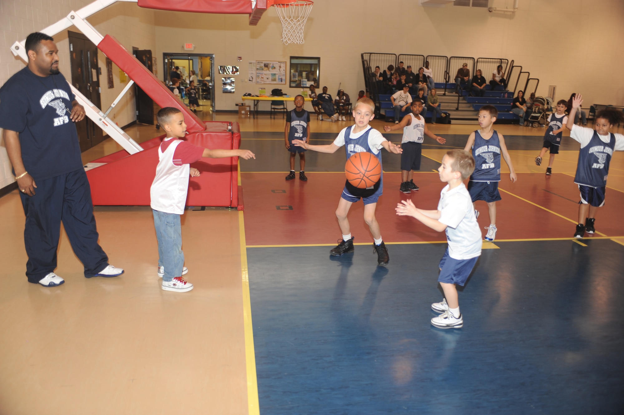 Townsend Tripple, Tigers center, goes for a steal as Quincy Harrell, Money forward, passes the ball to open teammate Nathan Barry, Money forward, during a 7-to 8-year-old end-of-season basketball game at the youth center on Seymour Johnson Air Force Base, N.C., March 13, 2010.  The Tigers and Money are two of the seven youth center basketball teams. Townsend is the son of Maj. Trent Tripple, 4th Operations Group director of staff.  Quincy is the son of Staff Sgt. Jamie Harrell, 4th Contracting Squadron contract specialist.  Nathan is the son of Staff Sgt. Thomas Barry, 4th Equipment Maintenance Squadron precision guided munitions crew chief.  (U.S. Air Force photo/Tech. Sgt. Lesley Waters)
