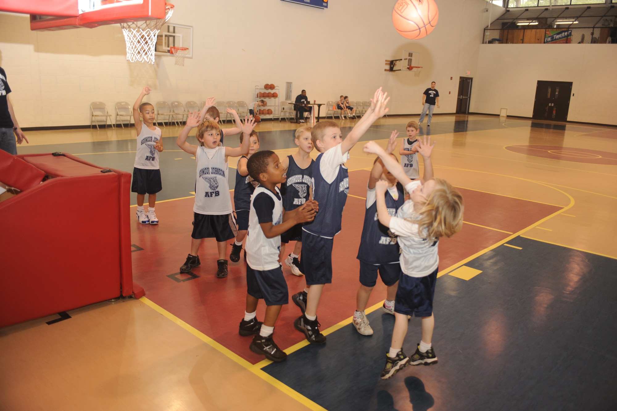 Ean Clymer, Bulls guard, shoots over the outstretched hands of Landry Waters, Fighting Dragons center, and McKinzie Freeman, Fighting Dragons guard, during a 5-to 6-year-old end-of-season basketball game at the youth center on Seymour Johnson Air Force Base, N.C., March 13, 2010.  Youth center basketball teams are broken up into four age groups for 5-to 12-year-old children.  Ean Clymer is the son of Tech. Sgt. Andrew Clymer, 916th Air Refueling Squadron fuel systems mechanic.  Landry is the son of Tech. Sgt. Lesley Waters, 4th Fighter Wing Public Affairs internal information noncommissioned officer in charge.  McKinzie is the daughter of Tech. Sgt. Jeremy Freeman, 4th Component Maintenance Squadron aerospace propulsion craftsman.  (U.S. Air Force photo/Tech. Sgt. Lesley Waters)