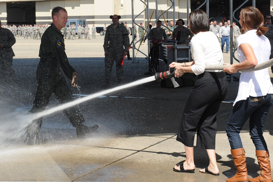 Col. Mark Kelly, 4th Fighter Wing commander, is hosed down by his wife, Tanya, and his daughter, Kara, in honor of his final flight in the F-15E Strike Eagle on Seymour Johnson Air Force Base, N.C., March 19, 2010. Kelly has been the commander of the 4th Fighter Wing since September 2008, but has been flying the F-15E since 1991. (U.S.  Air Force photo/Senior Airman Whitney Lambert) 