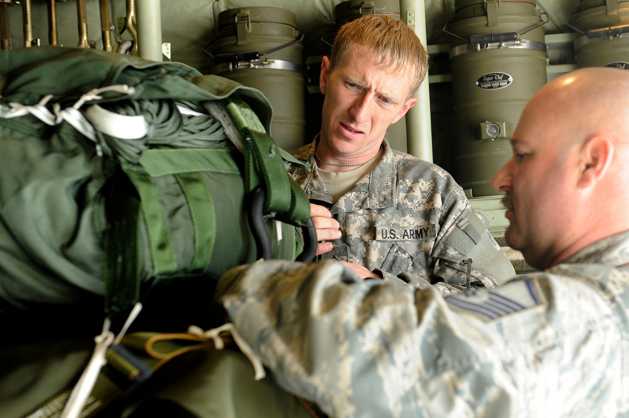 U.S. Army Sgt. Matthew Davenport, Combined Special Operations, and Air Force Master Sgt. Chuck Watkins, 774th Expeditionary Airlift Squadron, checks the parachutes on cargo loaded into a C-130J Super Hercules at Bagram Airfield, Afghanistan, March 2, 2010. Sergeant Davenport is deployed from Fort Bragg, N.C., and is from Mt. Olive, N.C. Sergeant Watkins is deployed from Channel Islands Air National Guard Base, Calif. (U.S. Air Force photo/Tech. Sgt. Jeromy K. Cross)