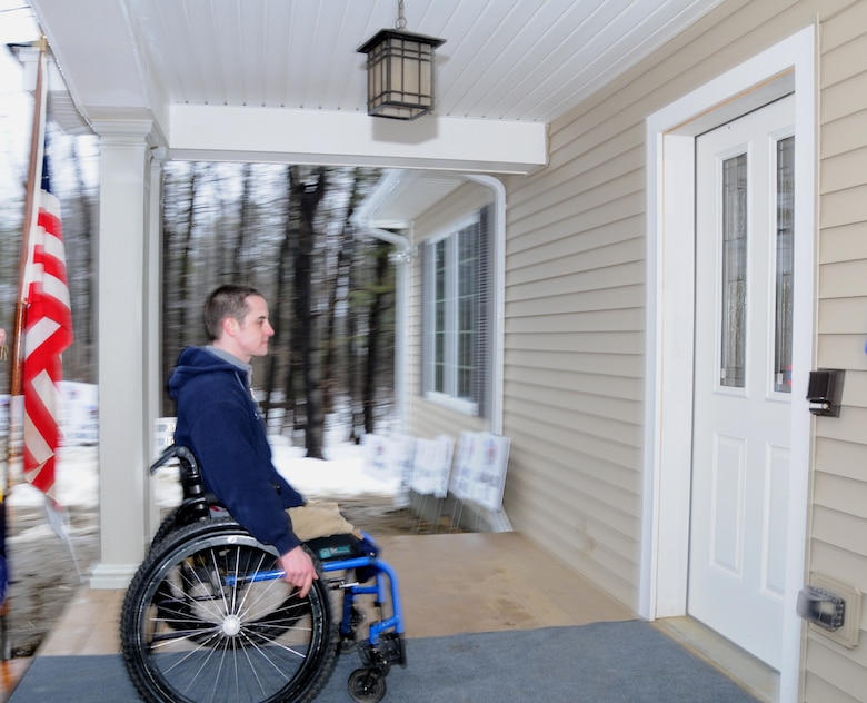 Army Sgt. Peter Rooney wheels toward the front door to unlock his new, specially-adapted home after receiving the key during an official key turnover ceremony in Worthington, Mass. March 13, 2010. Rooney has been anticipating moving into the home since framing began in summer of 2009. The Homes for Our Troops organization builds custom homes for severely disabled veterans through donations, volunteers and local community support. (U.S. Air Force photo by Tech. Sgt. Erin McNamara)