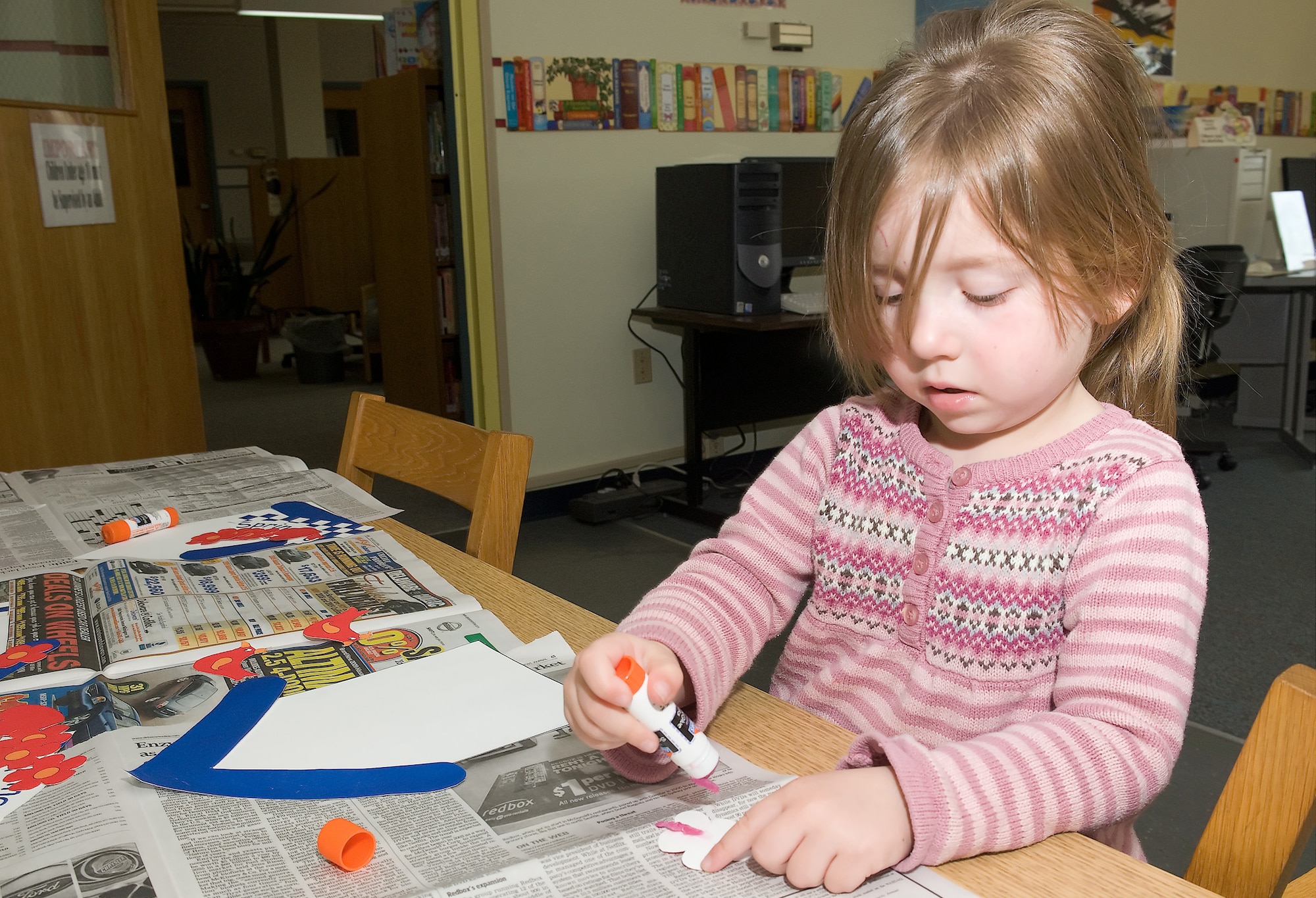 Four-year-old Katie Jordan, daughter of Staff Sgt. Meghann Roper, 436th Logistics Readiness Squadron, and Staff Sgt. Justin Roper, 736th Aircraft Maintenance Squadron, uses sticky glue to create a craft during Library Story Time March 17. (U.S. Air Force photo/ Brianne Zimny)