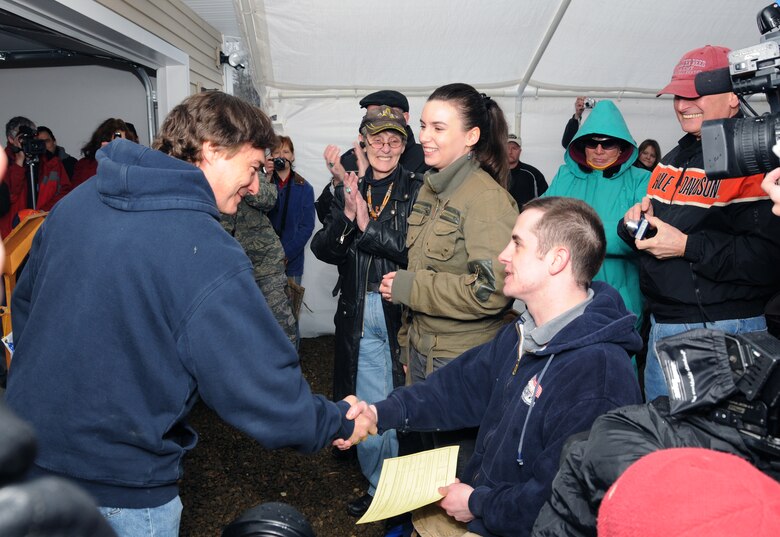 Kent Hicks, general contractor and owner of Hicks Construction, congratulates Army Sgt. Peter Rooney after presenting him with the certificate of occupation March 13, 2010, in Worthington, Mass. signifying that the new, specially-adapted home provided by Homes for Our Troops was now officially Rooney’s.  The Homes for Our Troops organization builds custom homes for severely disabled veterans through donations, volunteers and local community support. (U.S. Air Force photo by Tech. Sgt. Erin McNamara)