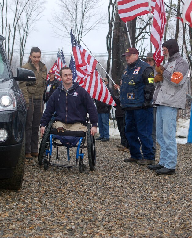 Army Sgt. Peter Rooney and his wife, Susanne Rooney, are greeted by Patriot Guard Riders as they exit their black SUV to take center stage for a key turnover ceremony for their new specially-adapted home in Worthington, Mass. March 13, 2010. Rooney lost both legs above the knee due to a roadside bomb in Ramadi, Iraq, April 16, 2007, after which, Homes for Our Troops gifted Rooney with a custom-built home that will accommodate his needs. (U.S. Air Force photo by Tech. Sgt. Erin McNamara)