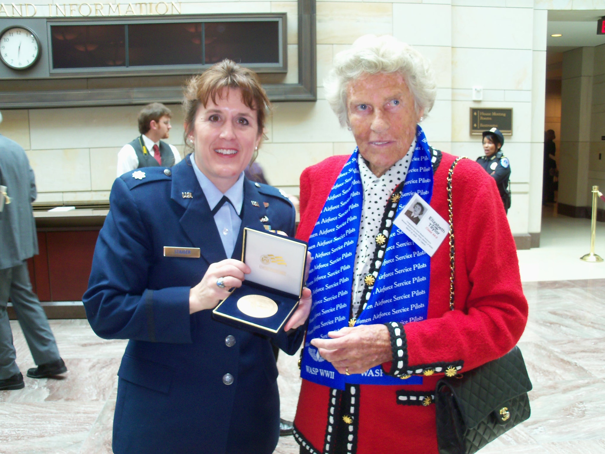 WRIGHT-PATTERSON AIR FORCE BASE, Ohio - Lt. Col. Kathryn Staiger, 445th Airlift Wing, admires the Congressional Gold Medal given to Ms. Elizabeth Taylor, Women's Airforce Service Pilot, March 10 during a ceremony on Capitol Hill.  More than 300 former WASP attended the ceremony to receive their medals for service to their country during World War II. (Courtesy photo) 