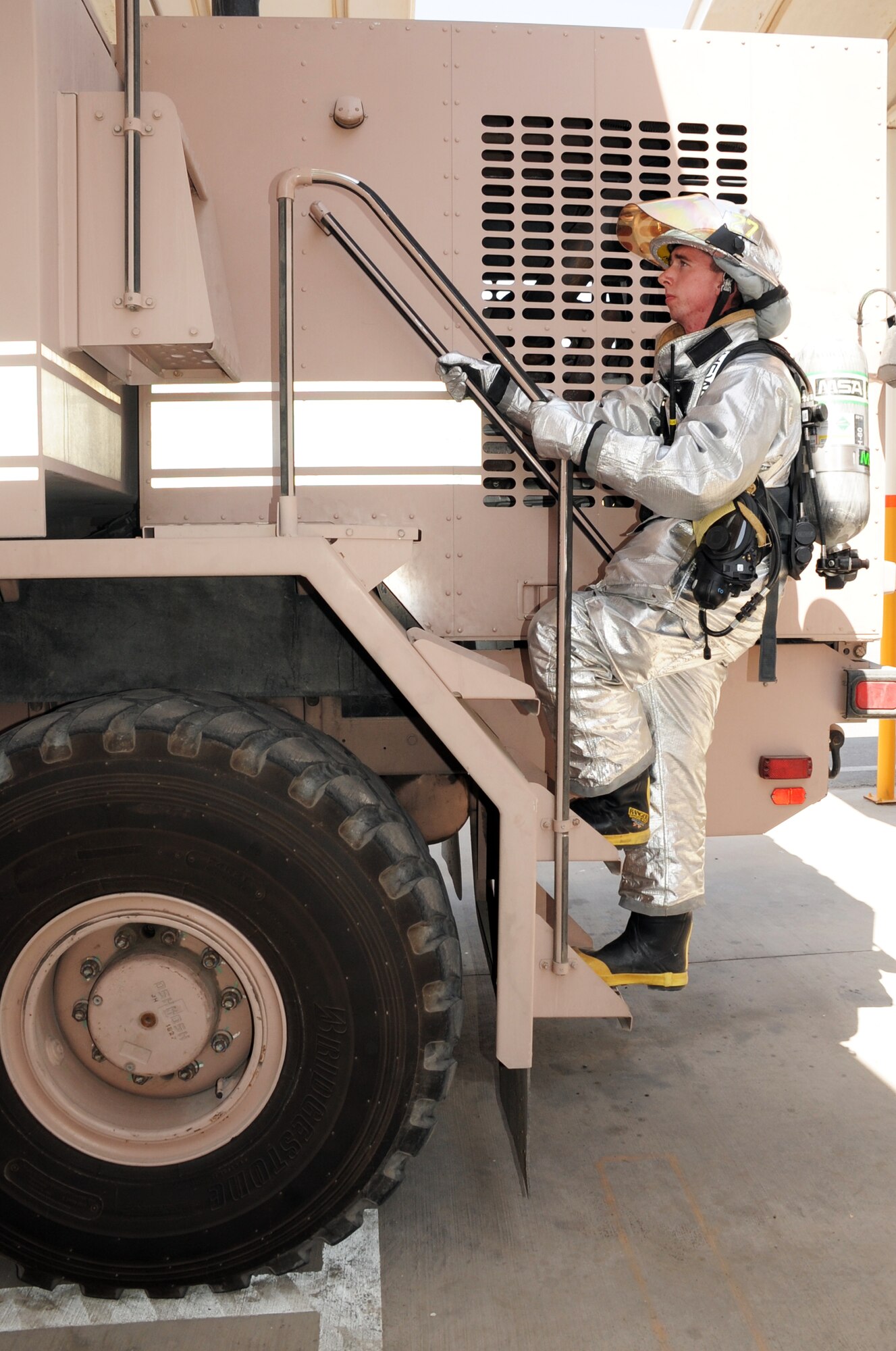 Airman 1st Class Samuel Siewert, firefighter with the 380th Expeditionary Civil Engineer Squadron fire department, climbs a fire truck while training at a non-disclosed base in Southwest Asia on March 14, 2010. As an Air Force firefighter, Airman Siewert and his fellow firefighters are responsible for protecting thousands of deployed personnel and billions of dollars of Air Force assets from fire. He is deployed from the 628th Civil Engineer Squadron fire department at Joint Base Charleston, S.C., and his hometown is Oconomowoc, Wisc. (U.S. Air Force Photo/Master Sgt. Scott T. Sturkol)