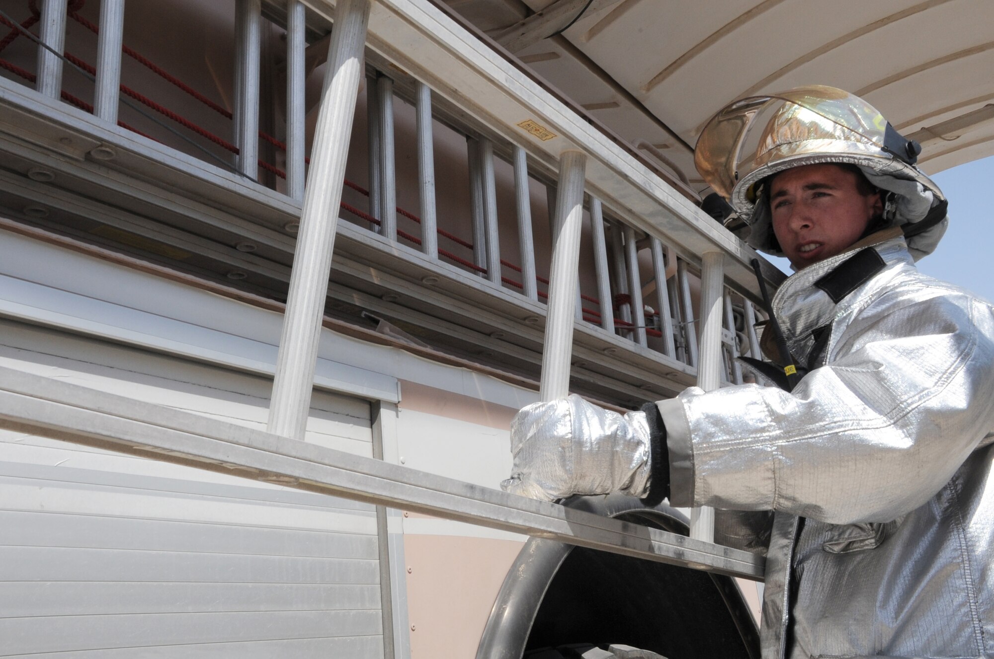 Airman 1st Class Samuel Siewert, firefighter with the 380th Expeditionary Civil Engineer Squadron fire department, moves a ladder from a fire truck while training at a non-disclosed base in Southwest Asia on March 14, 2010. As an Air Force firefighter, Airman Siewert and his fellow firefighters are responsible for protecting thousands of deployed personnel and billions of dollars of Air Force assets from fire. He is deployed from the 628th Civil Engineer Squadron fire department at Joint Base Charleston, S.C., and his hometown is Oconomowoc, Wisc. (U.S. Air Force Photo/Master Sgt. Scott T. Sturkol)