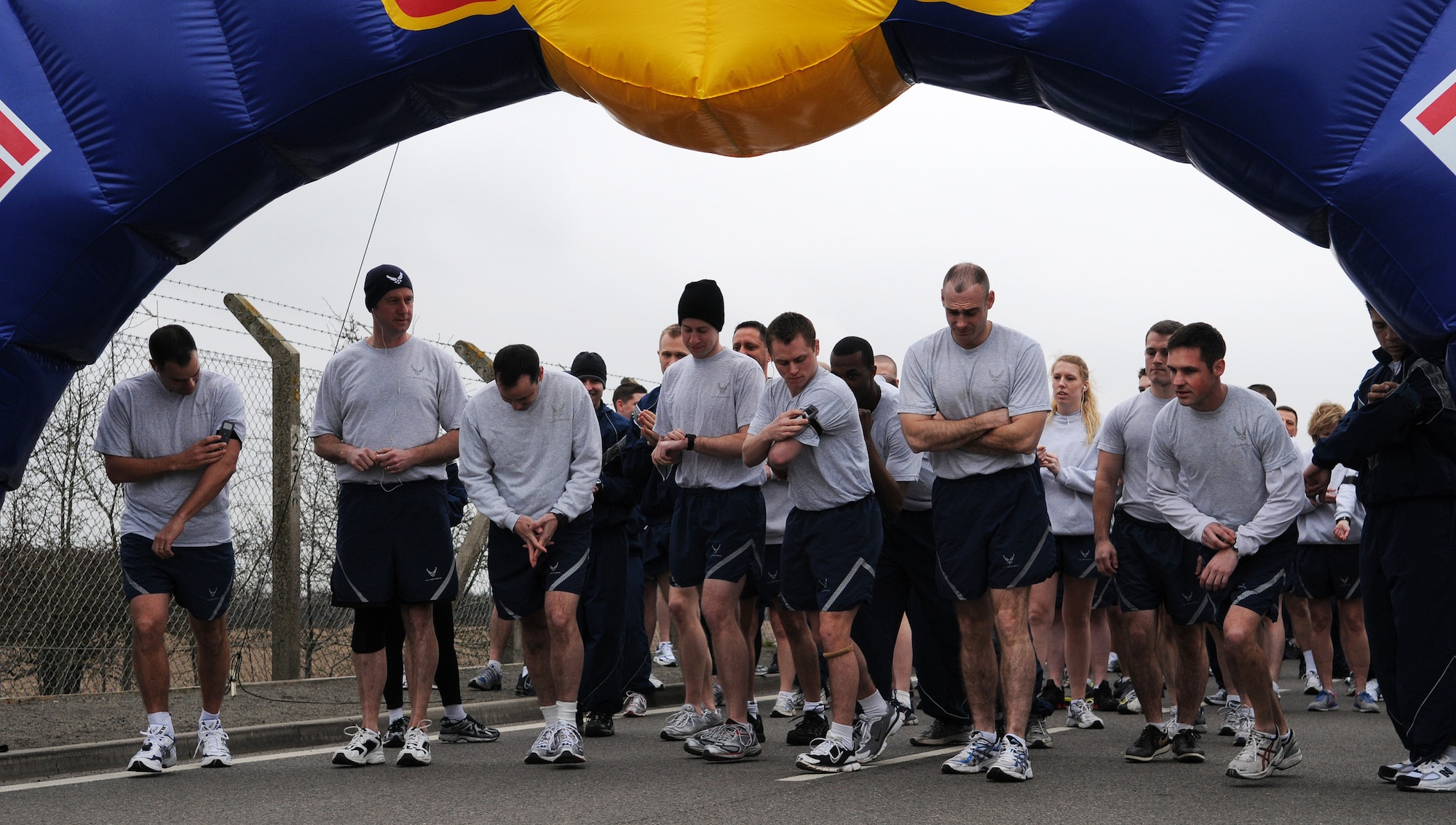RAF MILDENHALL, England -- RAF Mildenhall Airmen prepare to start their watches and music players seconds before the March Team Mildenhall 5K Fun Run near the Hardstand Fitness Center March 19. Hundreds of 100th Air Refueling Wing and tenant unit Airmen participated in the monthly run to promote health and fitness. Many runners turned around after finishing to backtrack and encourage their fellow Airmen to cross the finish line. (U.S. Air Force photo/Staff Sgt. Thomas Trower)