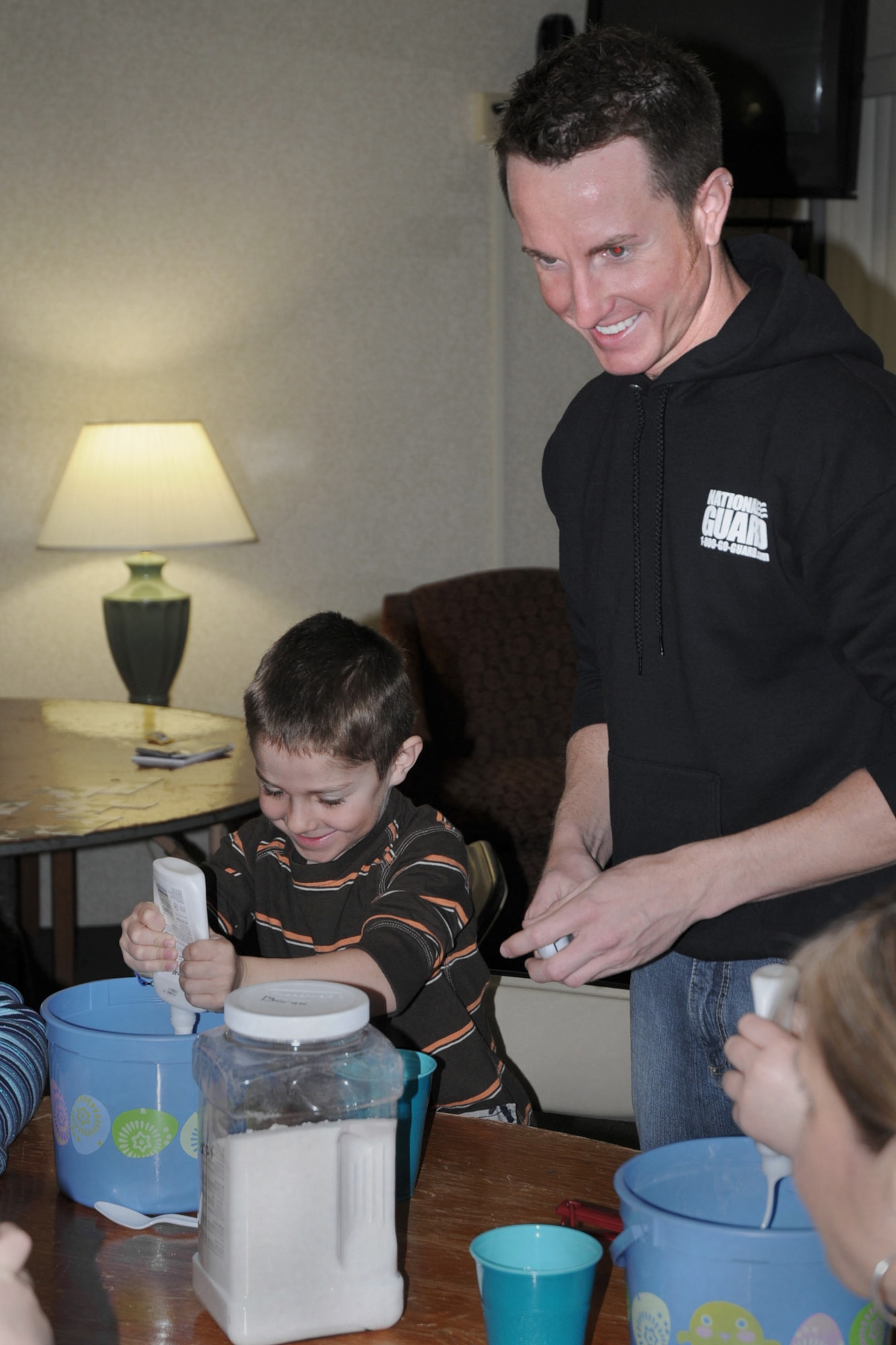 State Youth Coordinator Jeremy VanWyk (right) explains how to make ?slime? to children he is working with who?s parents are attending the Yellow Ribbon Event held at the Holiday Inn Airport in Des Moines, Iowa on March 6, 2010.  Childcare services were offered so parents could attend the event, which is designed to assist military members who have returned home from deployment and offer assistance to them as they transition back into civilian life.  (US Air Force photo/Staff Sgt. Linda E. Kephart)(Released)