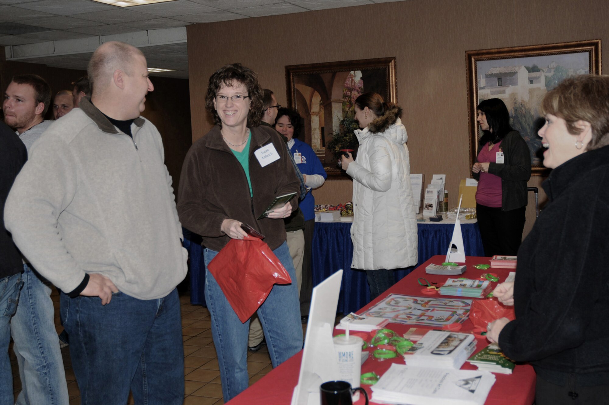 Master Sgt. Kurt Kollasch (left) and wife Susan (middle) enjoy each others company as they review information about the YMCA with representative Michelle Brainard (right) at the Yellow Ribbon Event held at the Holiday Inn Airport on March 6, 2010.  The Yellow Ribbon Event is designed to assist military members who have returned home from deployment and offer assistance to them as they transition back into civilian life.  (US Air Force photo/Staff Sgt. Linda E. Kephart)(Released) 