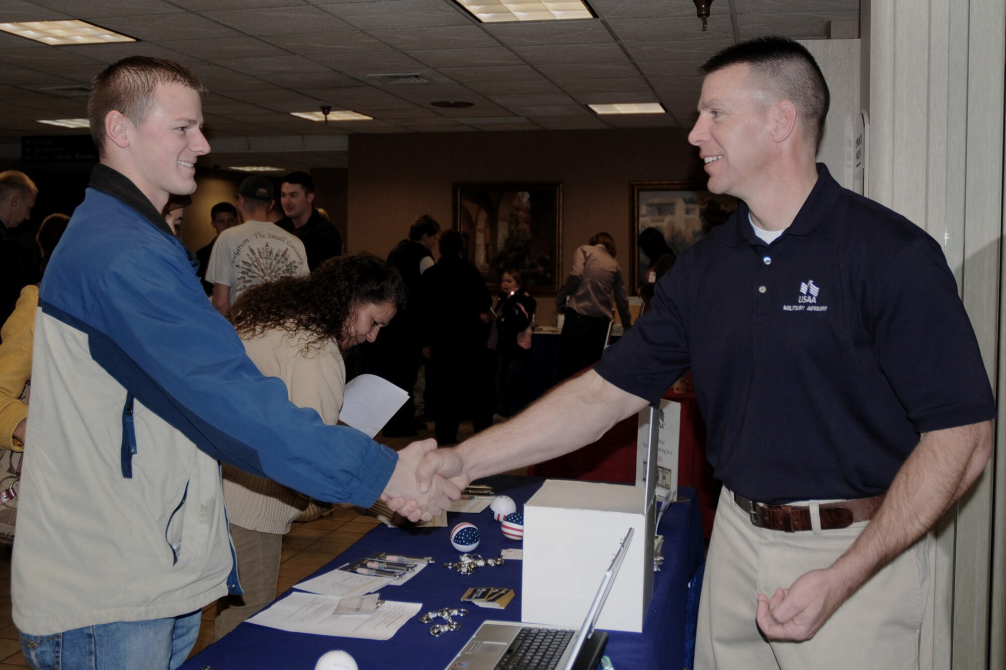 Staff Sgt. Joshua Brady (left) receives a coin from USAA Military Affairs Representative Michael Evans (right) at the Yellow Ribbon Event held at the Holiday Inn Airport in Des Moines, Iowa on March 6, 2010.  The coin is being presented to Sgt. Brady as a ?thank you? for his service and time spent overseas on a recent deployment.  (US Air Force photo/Staff Sgt. Linda E. Kephart)(Released)        
