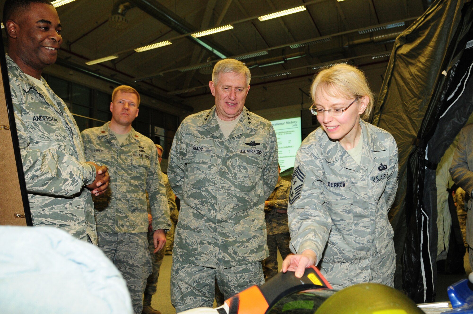 RAMSTEIN AIR BASE, Germany -- Chief Master Sgt. Pamela Derrow, U.S. Air Forces in Europe command chief master sergeant, and Gen. Roger A. Brady, USAFE commander, inspect personal protective equipment March 16, 2010, while Staff Sgt. Louis Anderson of the 435th Construction and Training Squadron explains how it is used. Chief Derrow and General Brady spent the day visiting the facilities of the 435th Air Ground Operations Wing, their first visit to USAFE's newest wing since it stood up in July 2009.  (U.S. Air Force photo by Airman Desiree Esposito)