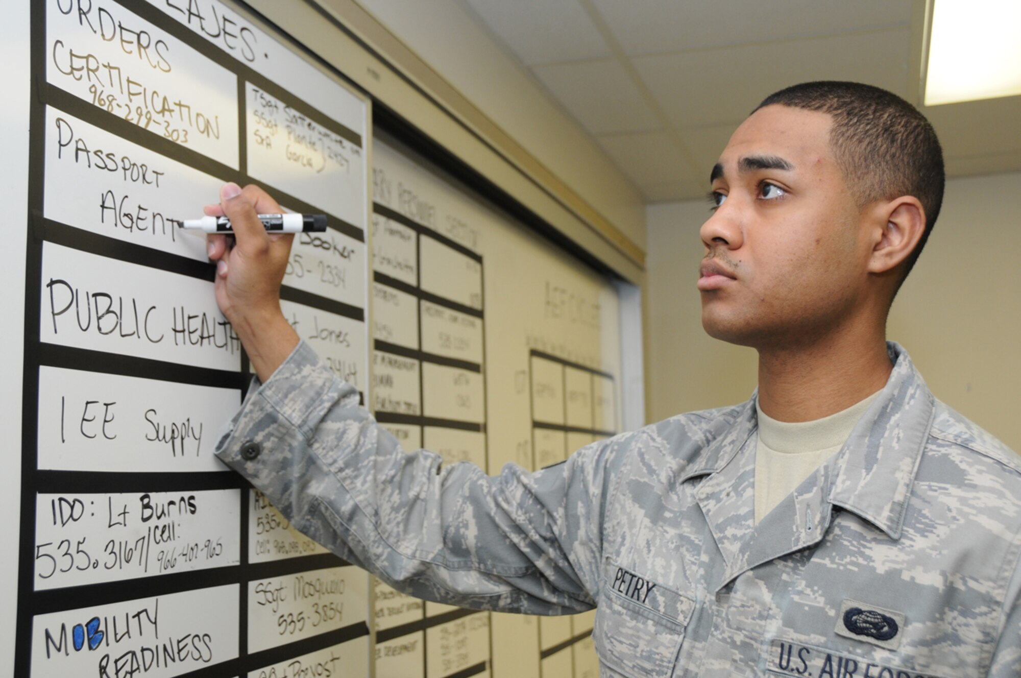 Senior Airman Byran Petry, 65th Force Support Squadron, puts the point of contacts for different agencies on his office board at Lajes Field, Azores.   Airman Petry, Installation Personnel Readiness Journeyman, was recently named the Air Force’s best “Airman Personnel Manager of the Year.” (U.S. Air Force photo/Guido Melo)