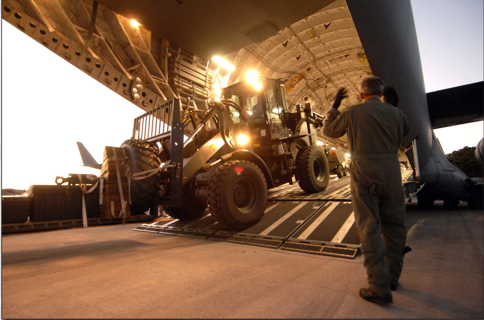 Senior Master Sgt. William J. Lamela, a loadmaster assigned to the 452nd Air Mobility Wing, March Air Reserve Base, Calif., directs the offloading of relief equipment and supplies from one of the wing's C-17s at the Port-au-Prince International Airport. (Master Sgt. Dawn Price)