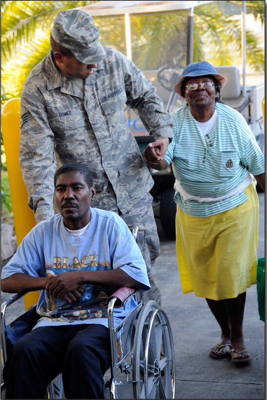 Staff Sgt. Johann Gomez of the 482nd Fighter Wing's civil engineer squadron helps move American survivors of the Haiti earthquake into the gymnasium at Homestead ARB. (Senior Airman Lou Burton)