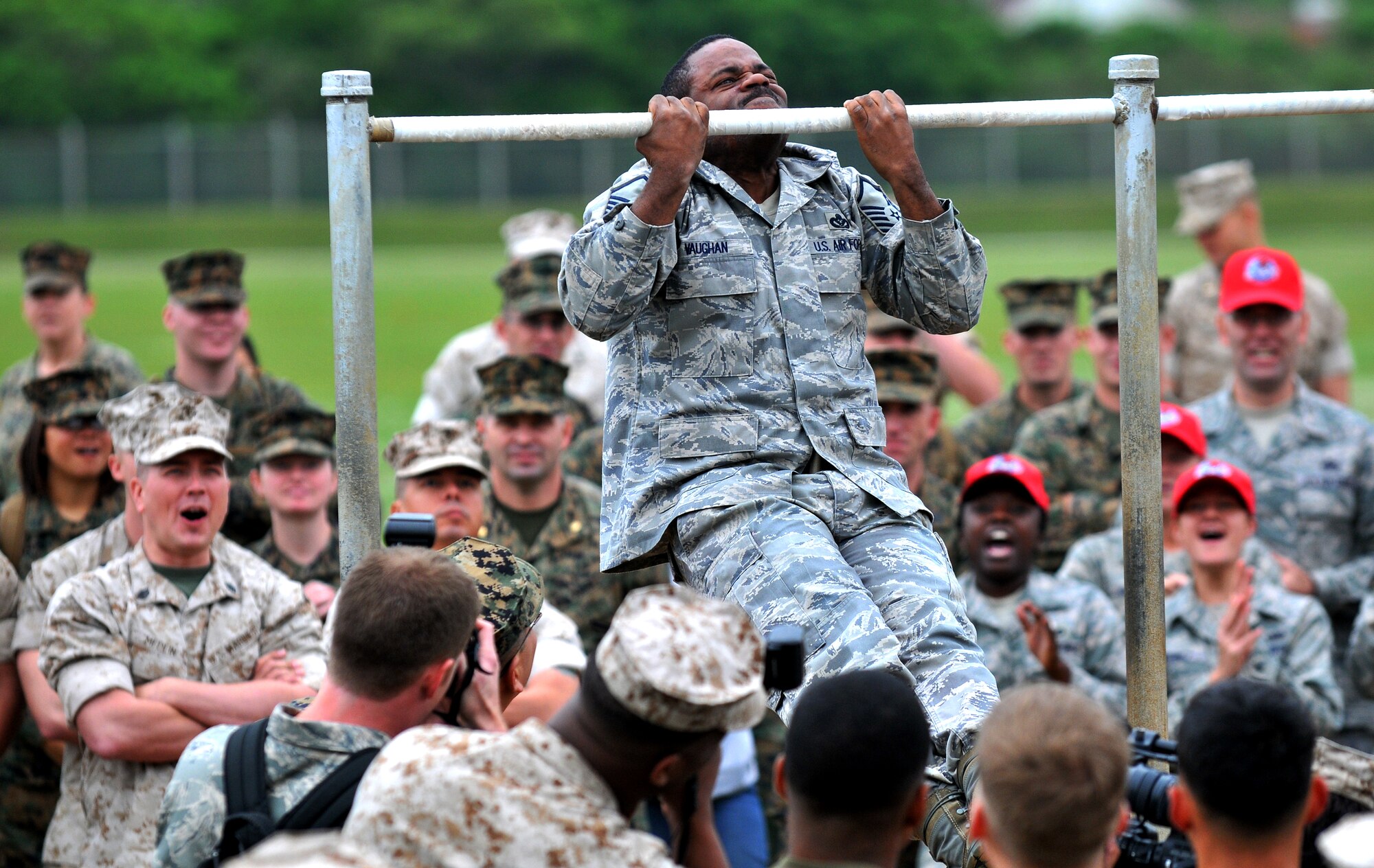 Master Sgt. Naim Vaughan, 554th Red Horse Squadron Detachment 1, strains for one more pullup as fellow servicemembers and engineers offer encouragement at Camp Hansen, Japan, March 17. Engineering units from the Air Force and the Marine Corps converged on Camp Hansen for a friendly inter-service competition held annually on St. Patrick's Day. St. Patrick is the patron saint of engineers. 
(U.S. Air Force photo / Tech. Sgt. Rey Ramon)