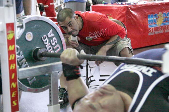 Jeremy Johnson, a 2010 Open Bench Press Competition judge, looks closely at the form of one of the weight lifters during the competition at the IronWorks Gym here March 20. Competitors were disqualified if they heaved or bounced the bar off their chest, or if they lifted their feet or back off the bench as they pressed the bar upward.