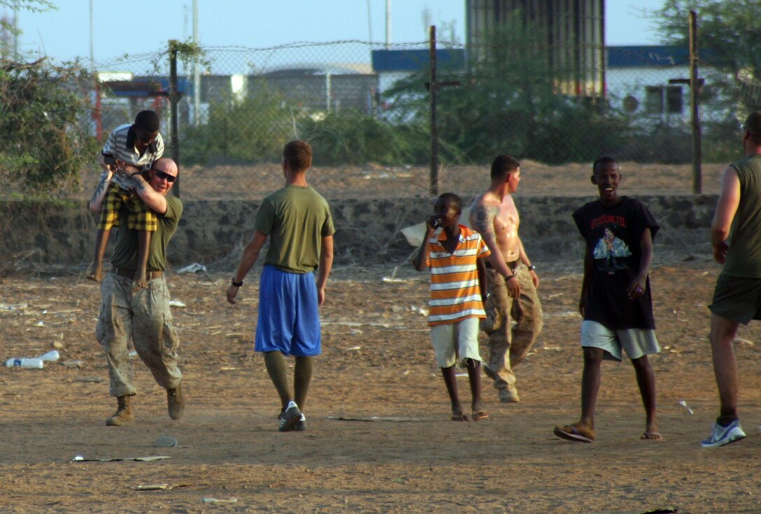 Sgt. Brian Behan, section leader, 81mm Mortar Platoon, Weapons Company, Battalion Landing Team 1st Battalion, 9th Marine Regiment, 24th Marine Expeditionary Unit, congratulates his teammate during a soccer game at a community outreach event at the National School for the Protection of Children in Djibouti City, Djibouti, March 20. The Marines took time out from their training schedule to talk with the children and squeeze in a few soccer games at two such outreach events on March 20 and March 26.  The 24th MEU is currently conducting a series of training exercies in Djibouti while deployed as the theater reserve for Central Command. The 24th MEU is an expeditionary, rapid-response force ready to perform a variety of missions ranging from humanitarian relief to full-scale combat operations.  (U.S. Marine Corps photo by Gunnery Sgt James Frank)