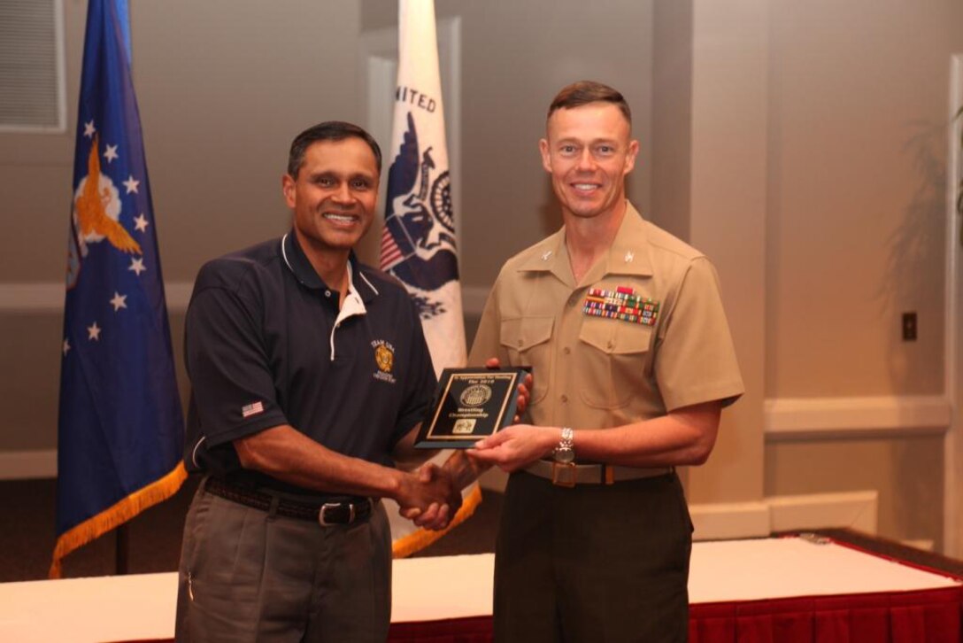 Mr. Suba Saty, secretariat with Armed Forces Sports, presents Col. Richard P. Flatau Jr., commanding officer of Marine Corps Base Camp Lejeune, a plaque of appreciation at the Ball Center for his hospitality and enthusiasm while hosting the 2010 Armed Forces Wrestling Championships aboard Marine Corps Base Camp Lejeune.