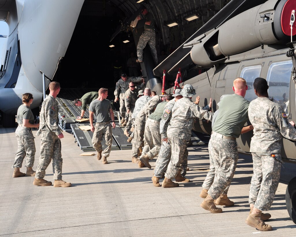 Joint Task Force-Bravo members keep a UH-60 Blackhawk straight while loading it onto a C-17 Globemaster III March 20 before deploying March 21 from Soto Cano Air Base, Honduras to Port au Prince, Haiti. Team Soto Cano is sending 40 personnel and four UH-60s to support Joint Task Force-Haiti airlift operations as part of the disaster relief mission Operation Unified Response. (U.S. Air Force photo/Staff Sgt. Bryan Franks) 