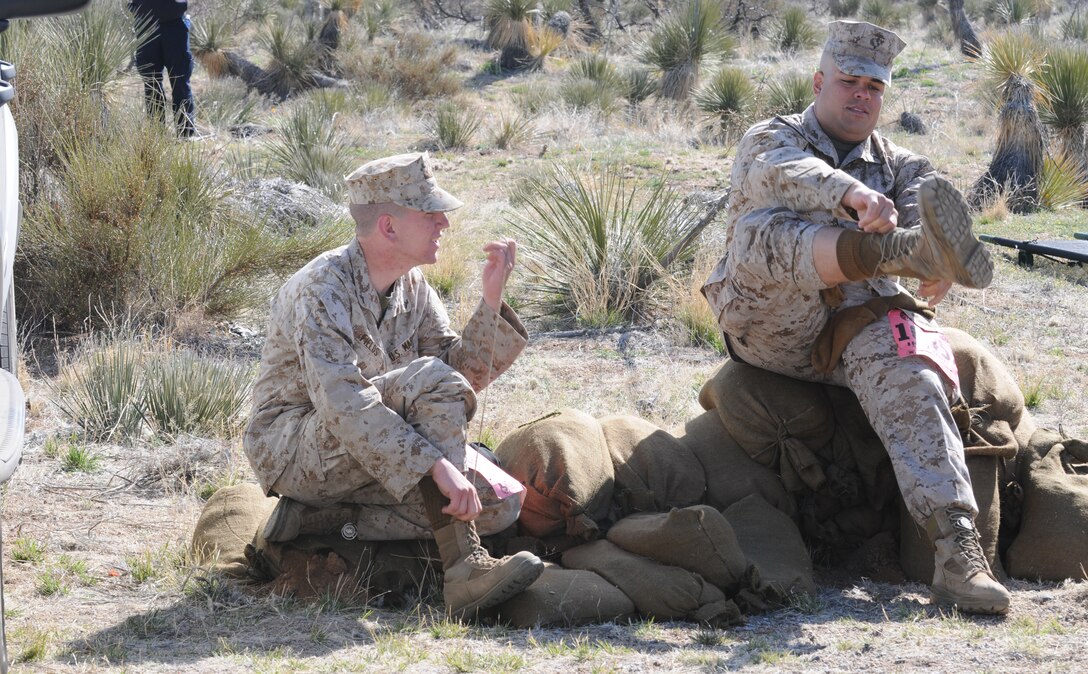 Yuma-based Marines Lance Cpl. Shane Fields, left, and Pfc. Adrian Velasquez change socks at one of the rest stops on the 26.2-mile Bataan Memorial Death March course at White Sands Missile Range, N.M., March 21, 2010. The annual march is held in memory of the nearly 75,000 American and Filipino service members forced to march across 90 miles of the Philippine Bataan peninsula with limited rations and harsh heat while interned by the Japanese in 1942. Marchers encountered sprains, blisters, sore spots and dehydration during the trek. The terrain throughout the course constantly shifted, from gravel to dirt to loose sand. “I just have a lot of respect for people that do these,” said Army Sgt. Ignacio Garza, combat medic with White Sands’ McAfee Health Clinic. “The human spirit can overcome a lot.” At least nine Marines from the Marine Corps Air Station in Yuma, Ariz., participated in the event.