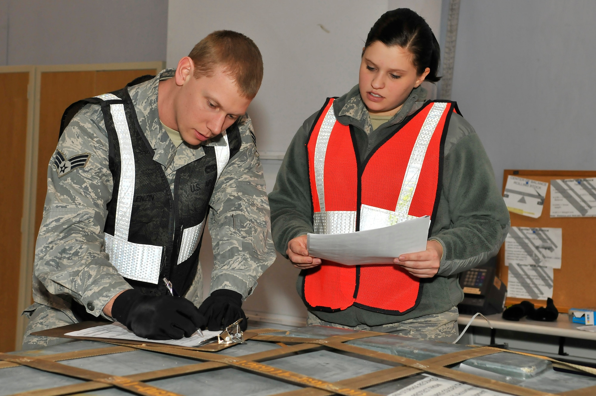 Senior Airman Ryan Wollenzin and Airman 1st Class Makenzie Baker review a cargo checklist at the Joint Mobility Center during exercise Golden Raven 10-2 Mar. 21, 2010, Eielson Air Force Base, Alaska. Airmen Wollenzin and Baker are assigned to the 354th Logistics Readiness Squadron. (U.S. Air Force photo/Staff Sgt. Christopher Boitz/released)