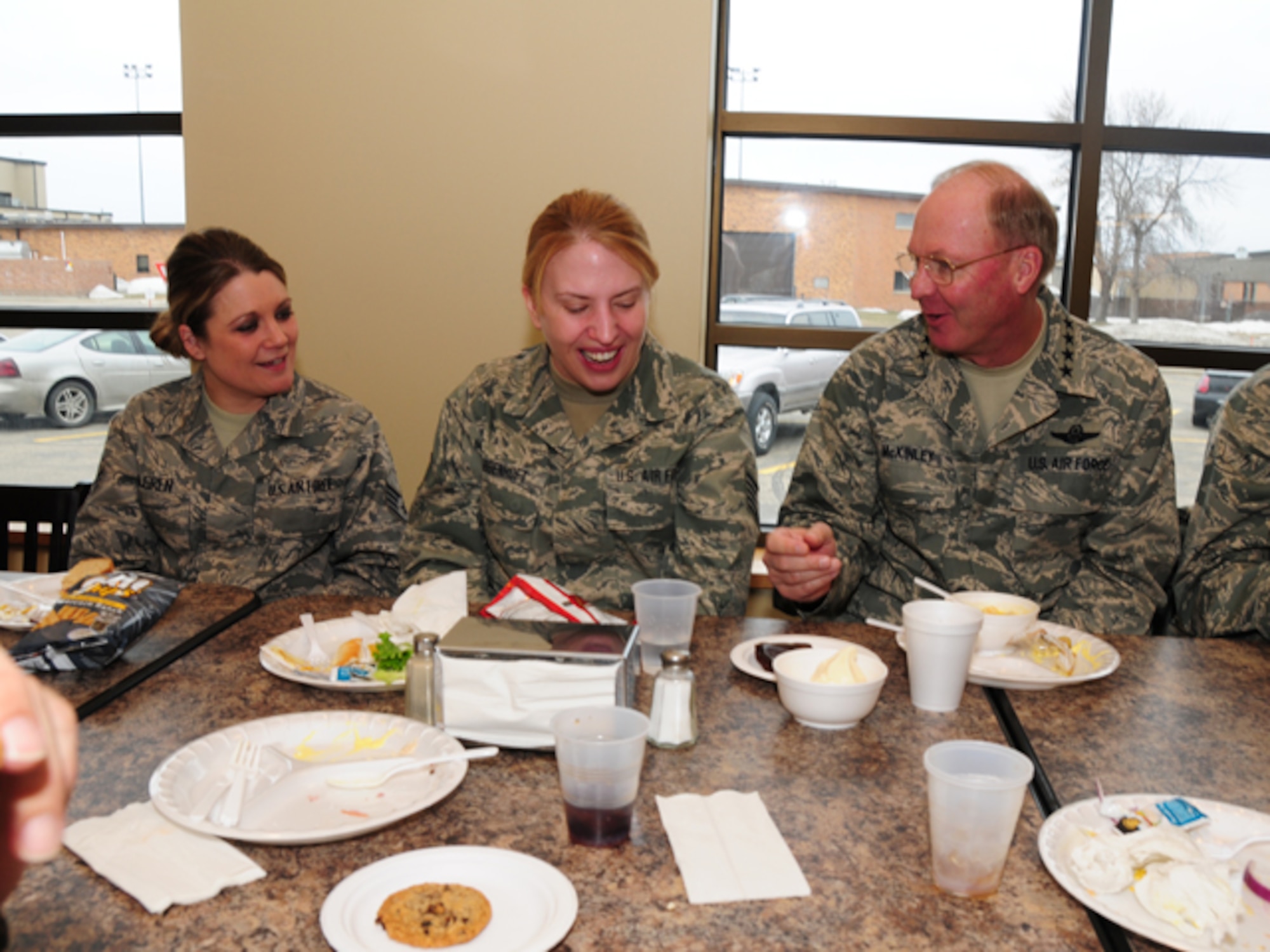 Gen. Craig R. McKinley, chief of the National Guard Bureau, laughs with Staff Sgt. Kristi Krabbenhoft, 119th Wing, while eating lunch at the 119th Wing on March 22.  McKinley ate with more than a dozen North Dakota Guardsmen and took time to talk about the ongoing flood operations taking place in the area.  
