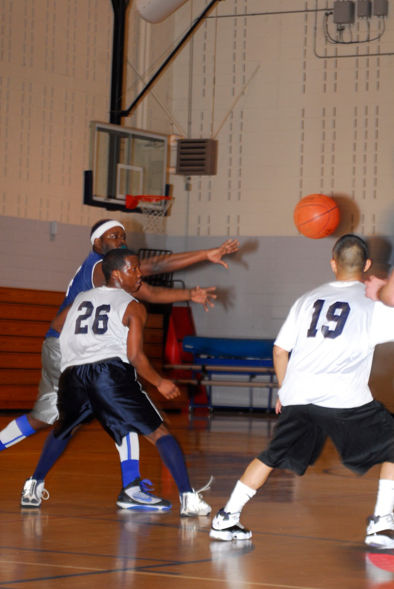 Senior Airman Jason Abney, 43rd Logistics Readiness Squadron, passes the basketball to a teammate as Airman Marwin Luna, 43rd Medical Group, attempts an interception during the intramural basketball championship March 15. (U.S. Air Force Photo by 2nd Lt. Cammie Quinn)